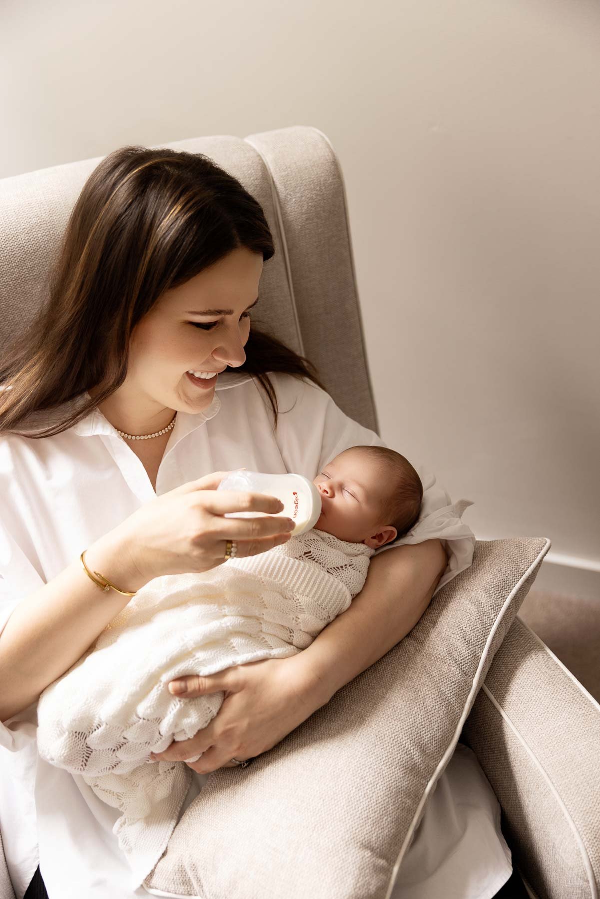 mother bottle feeding her baby, newborn photography