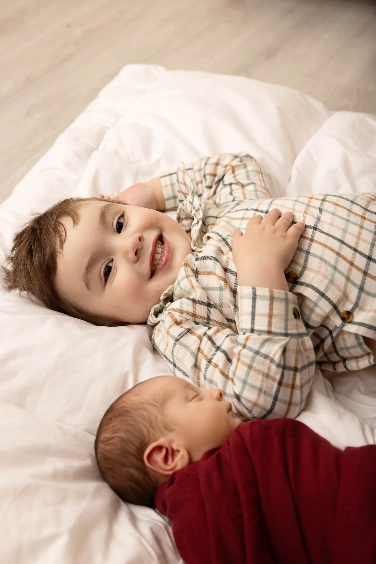 Newborn photographer Sydney Inner West
big sister looking down at her baby brother that is wrapped in white
this photograph I did for a Family from Ryde.