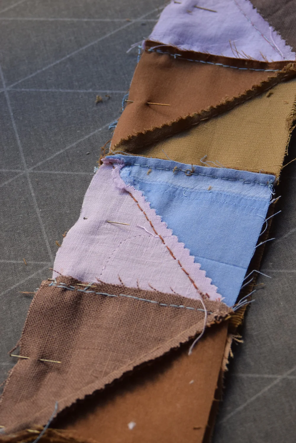 Deux bandes de carrés bicolores épinglées ensemble, prêtes à être assemblées