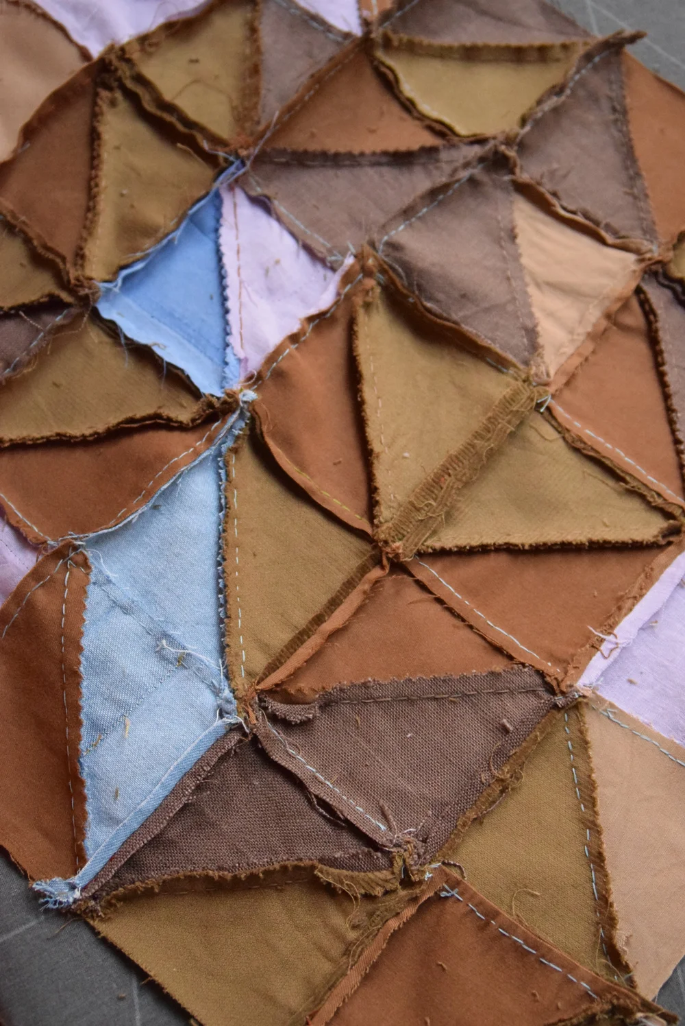 Envers d'un bloc de patchwork en train dêtre repassé avec marges de couture ouvertes