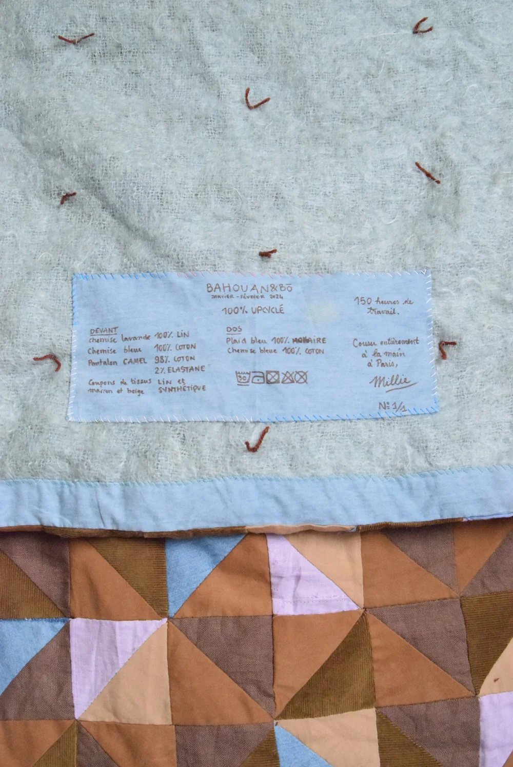 Dos en mohair sur lequel a été rajoute une étiquette textile faite main et des nœuds pour consolider les deux couches de tissus.