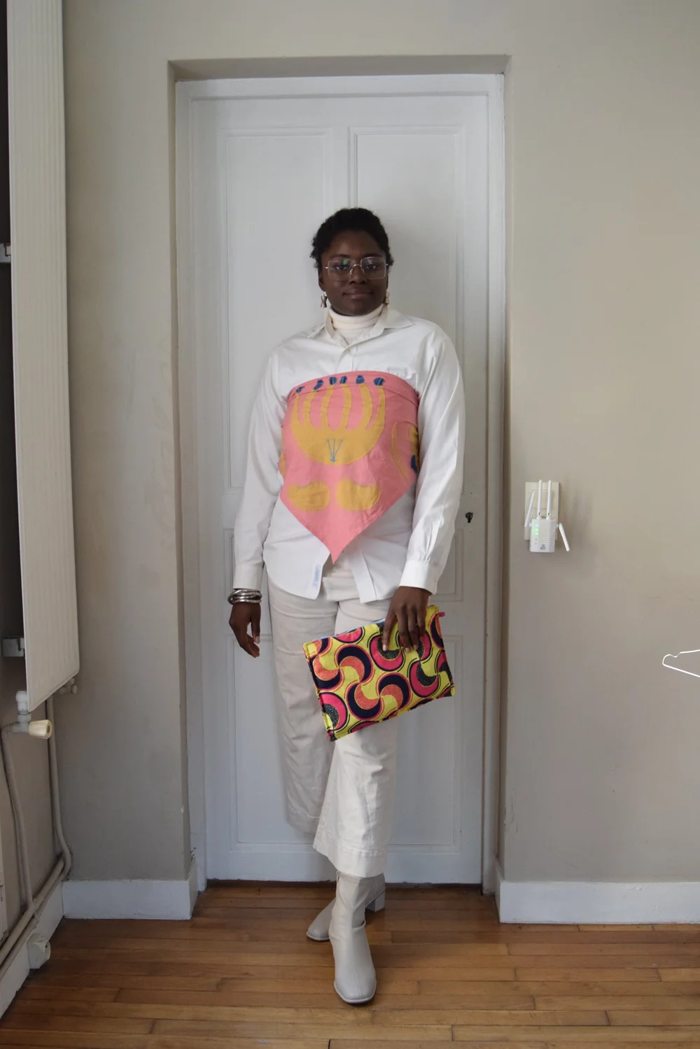 Chemise, pantalon, chaussures et boucles d'oreilles, le tout de seconde main. Maxi bandana rose brodé (porté sur la chemise) et pochette cousus en chutes de tissus.