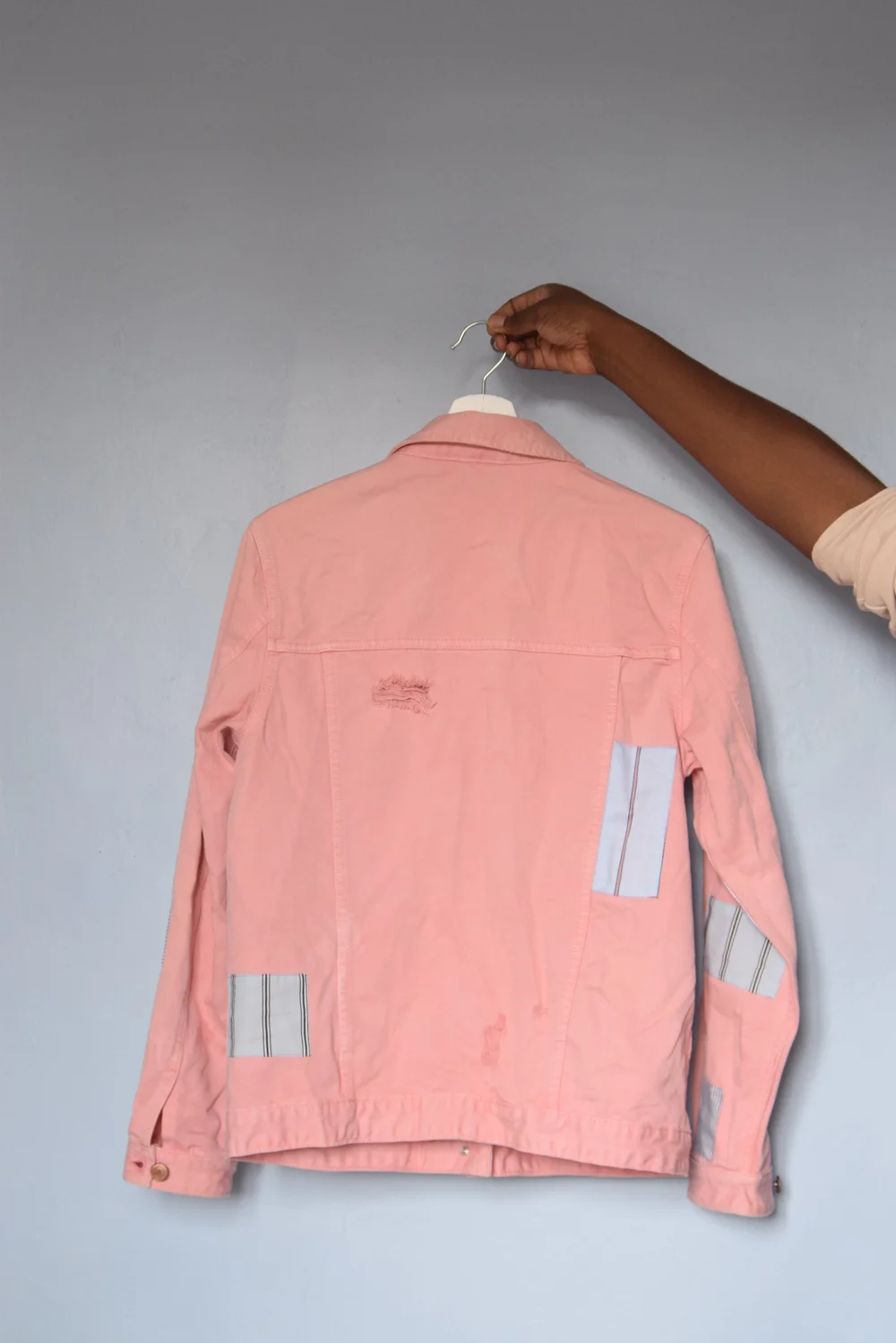 Veste en jean de seconde main customisée avec des chutes de tissus et de vêtements.