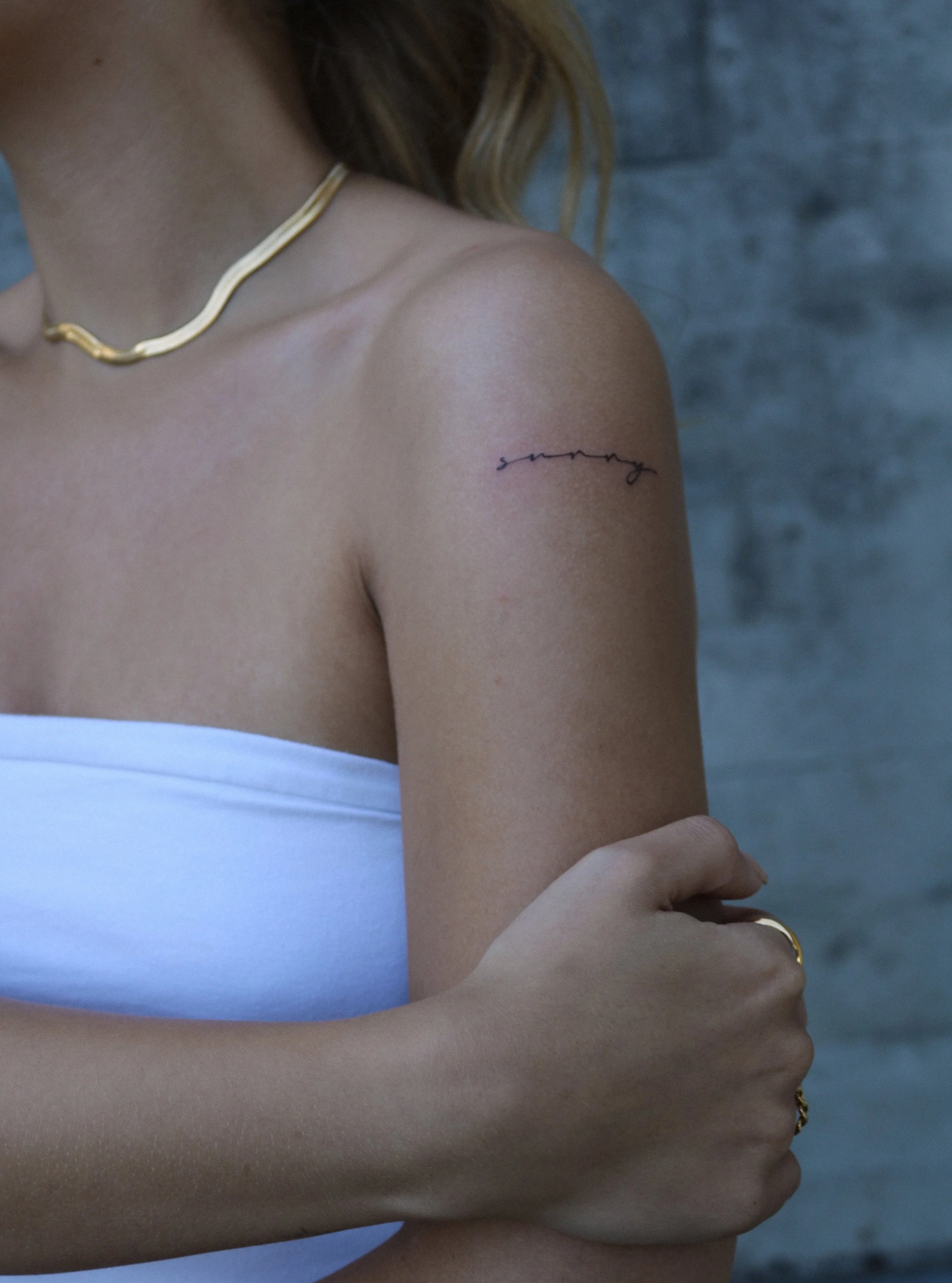 Eine Frau mit einem Tattoo auf der Schulter.