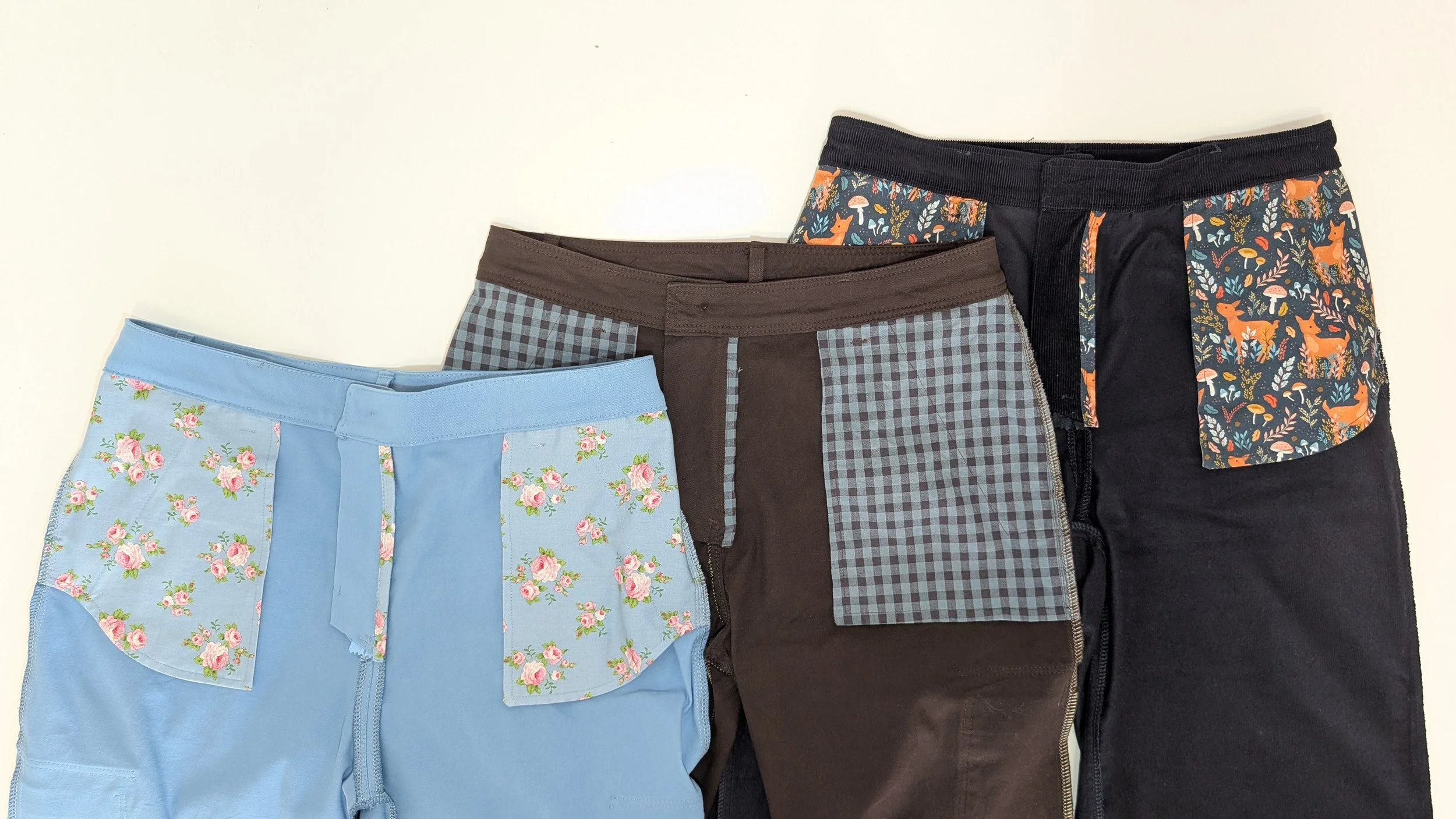 photo of the inside of 3 pairs of pants/trousers on a table