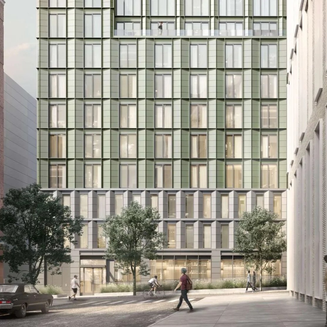 A modern high-rise building with a green facade and large windows, with trees and people walking on the sidewalk in front.