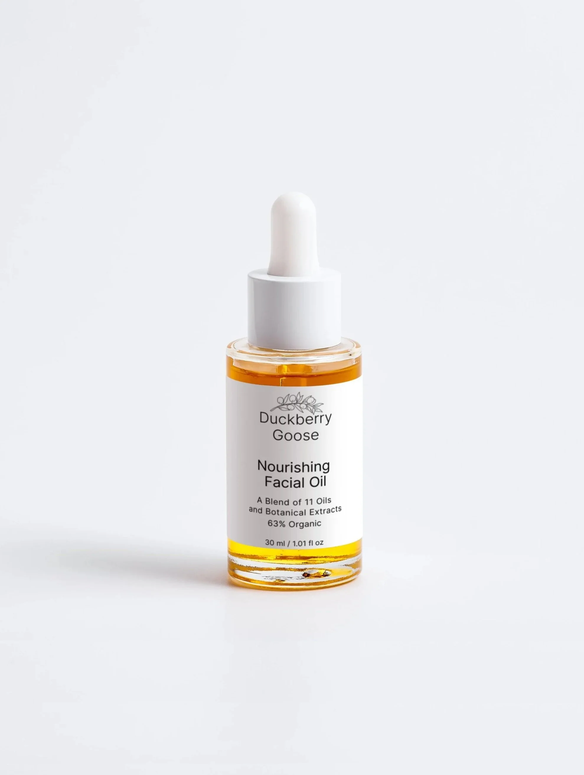 Golden facial oil in a glass dropper bottle with white box from Duckberry Goose. Product title: Nourishing Facial Oil.