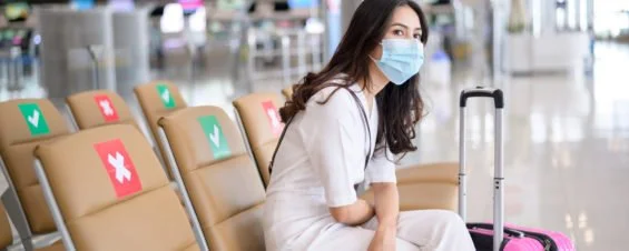 Woman Wearing a Mask Sitting in an Airport