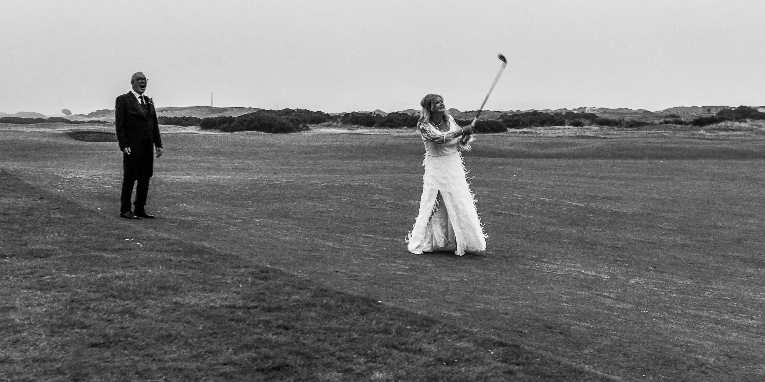 St Andrew's Old Course wedding photograph with the pro-golfer bride taking a shot on the fairway.