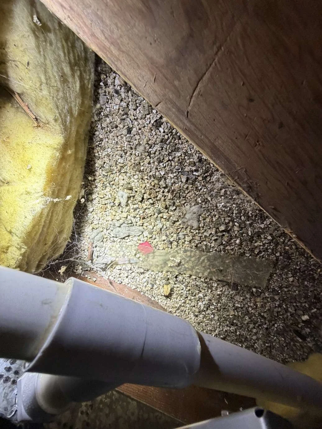 Suspect vermiculite insulation observed in an attic area during a Chicago asbestos inspection; laboratory testing required to confirm asbestos content.