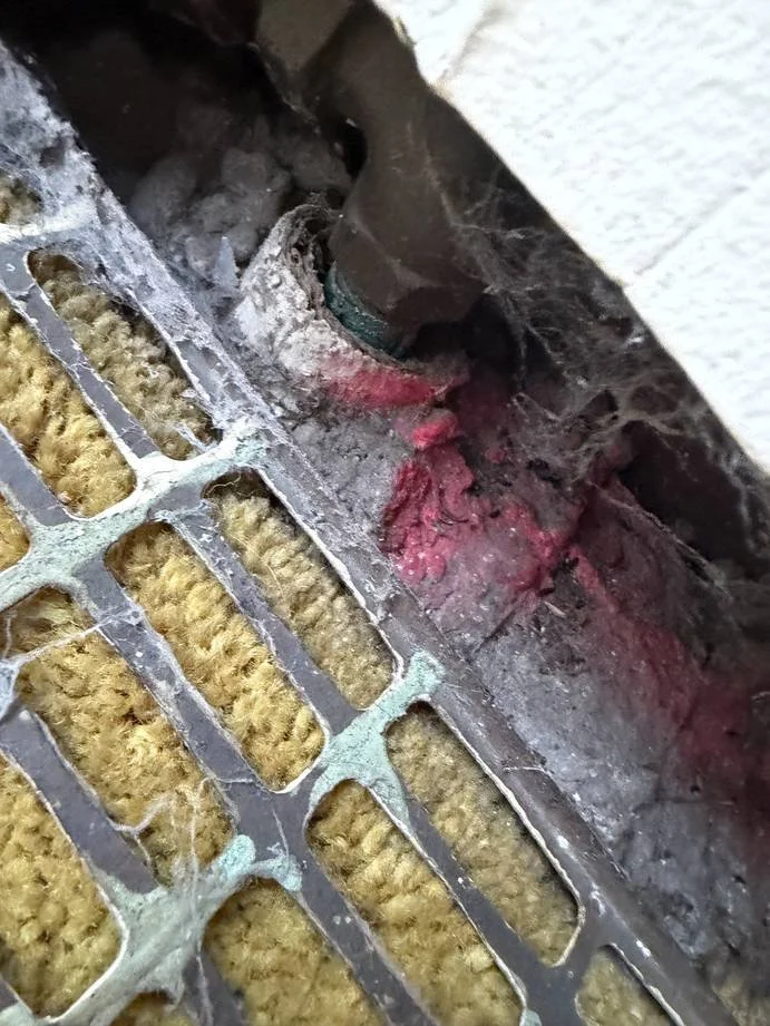 Suspect insulation material observed inside floor ductwork during a Chicago asbestos inspection; laboratory testing required for confirmation.