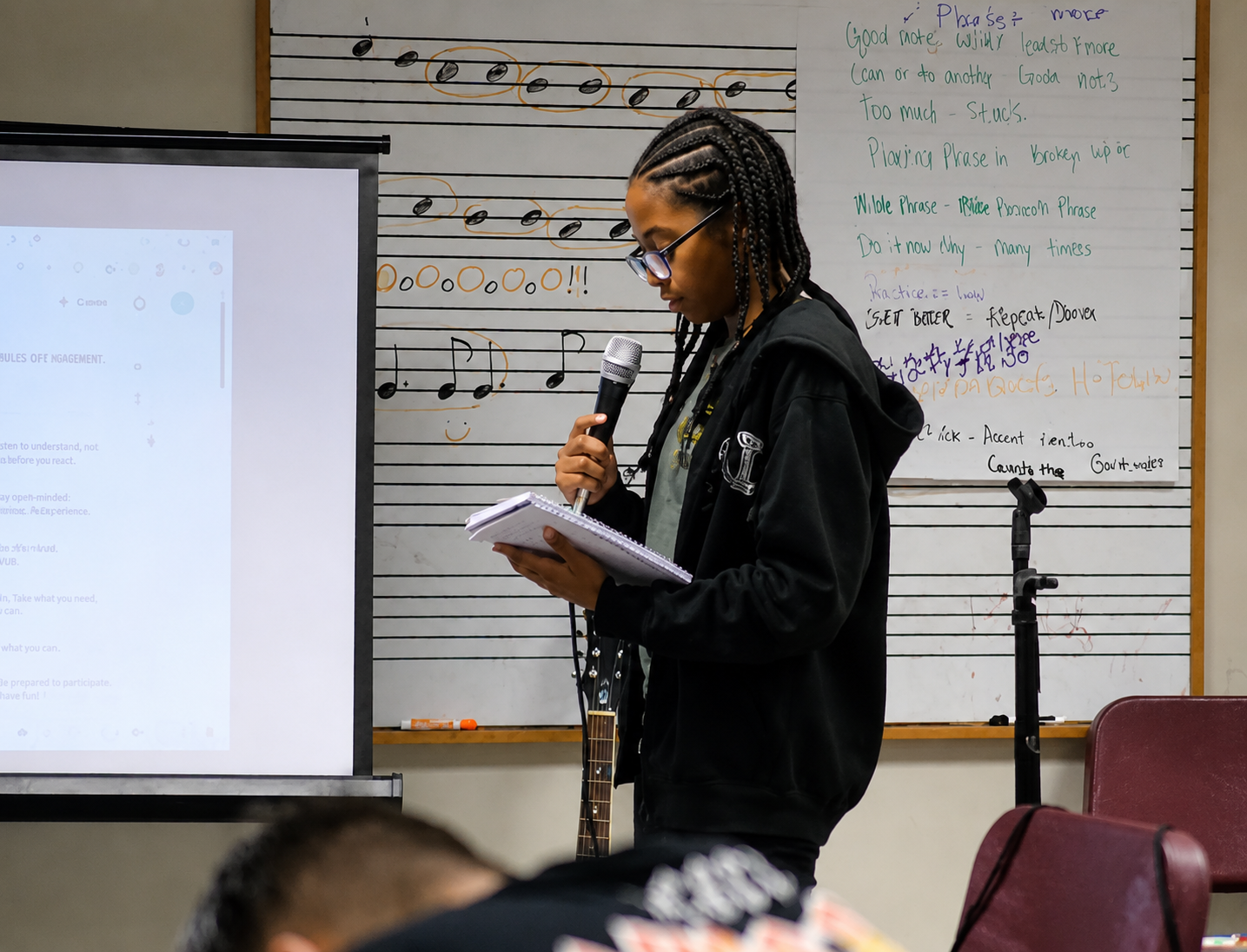 A Voices Unbound participant reading from her notebook into a microphone
