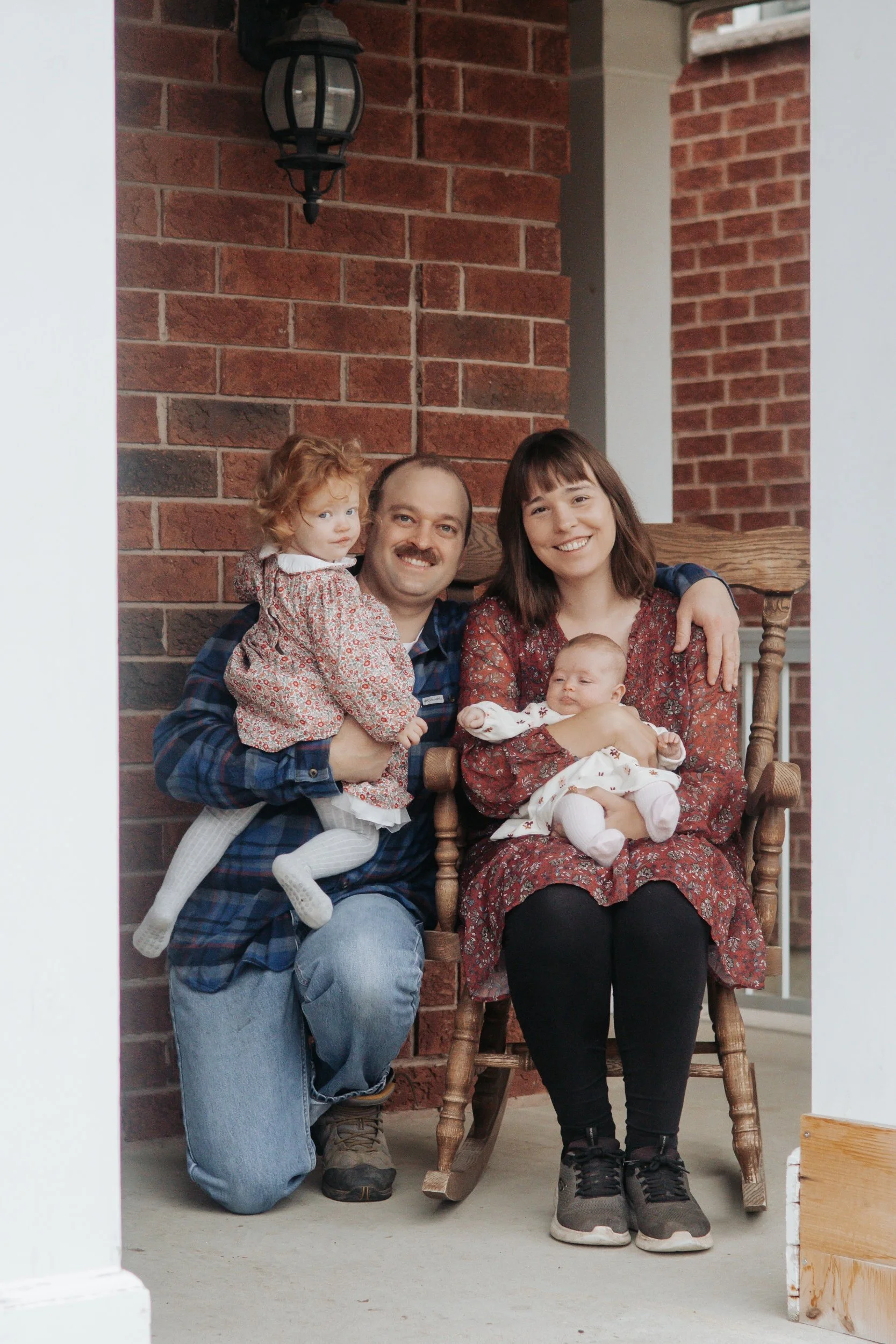 family of four on front porch Lifestyle newborn family photography in uxbridge ontario