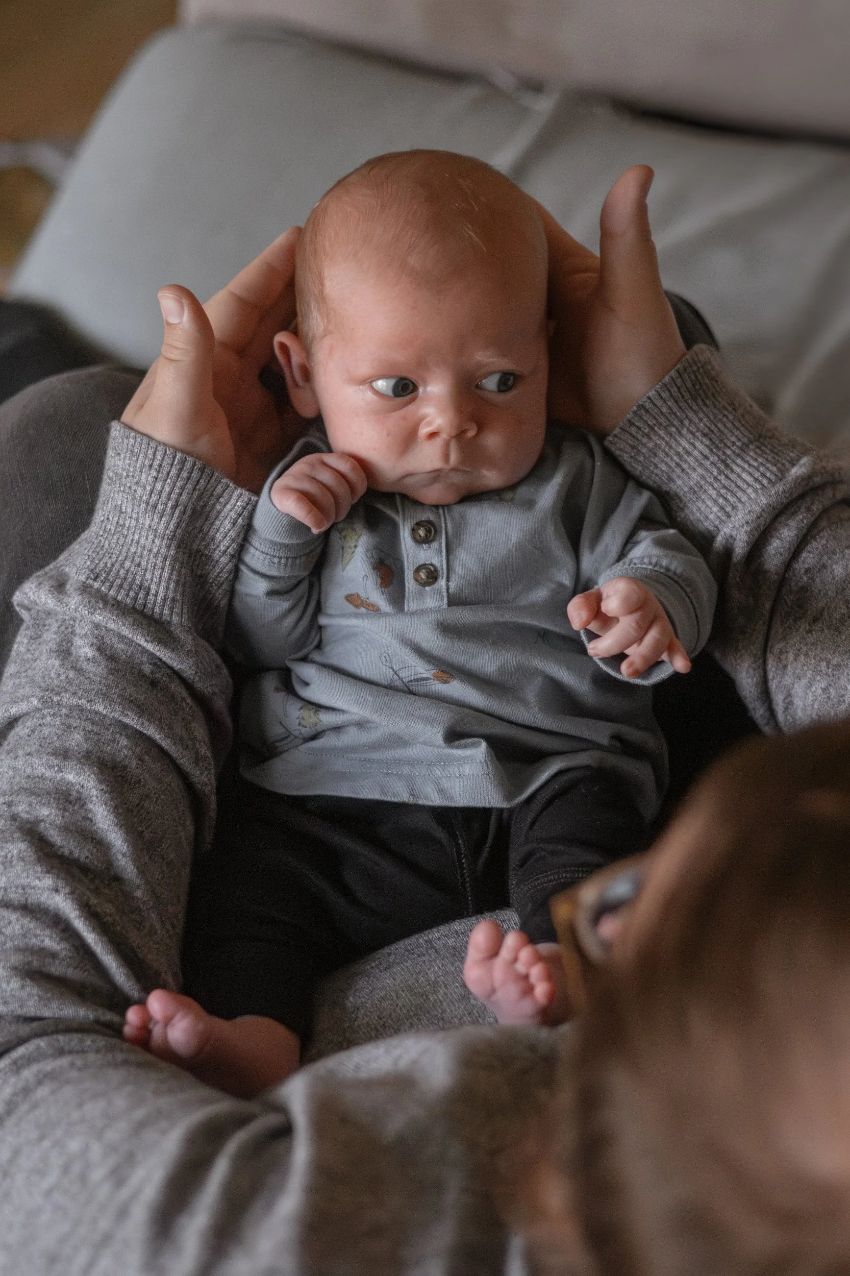 photo of a baby in his dad's arms Lifestyle newborn family photography in uxbridge ontario