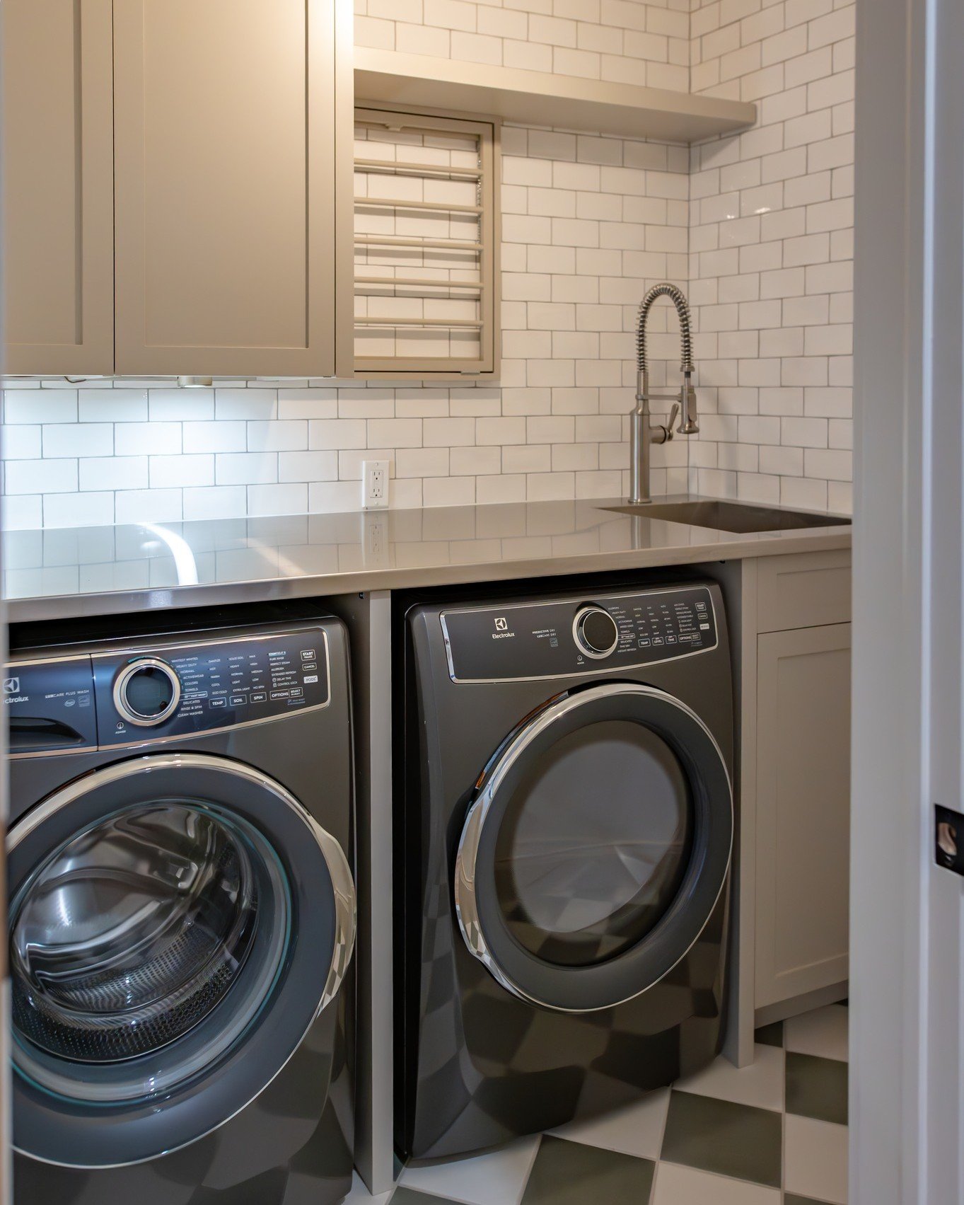 Modern country  style Laundry Room with stainless steel counter, griege cabinetry, white subway tile and green and white checkerboard floor
