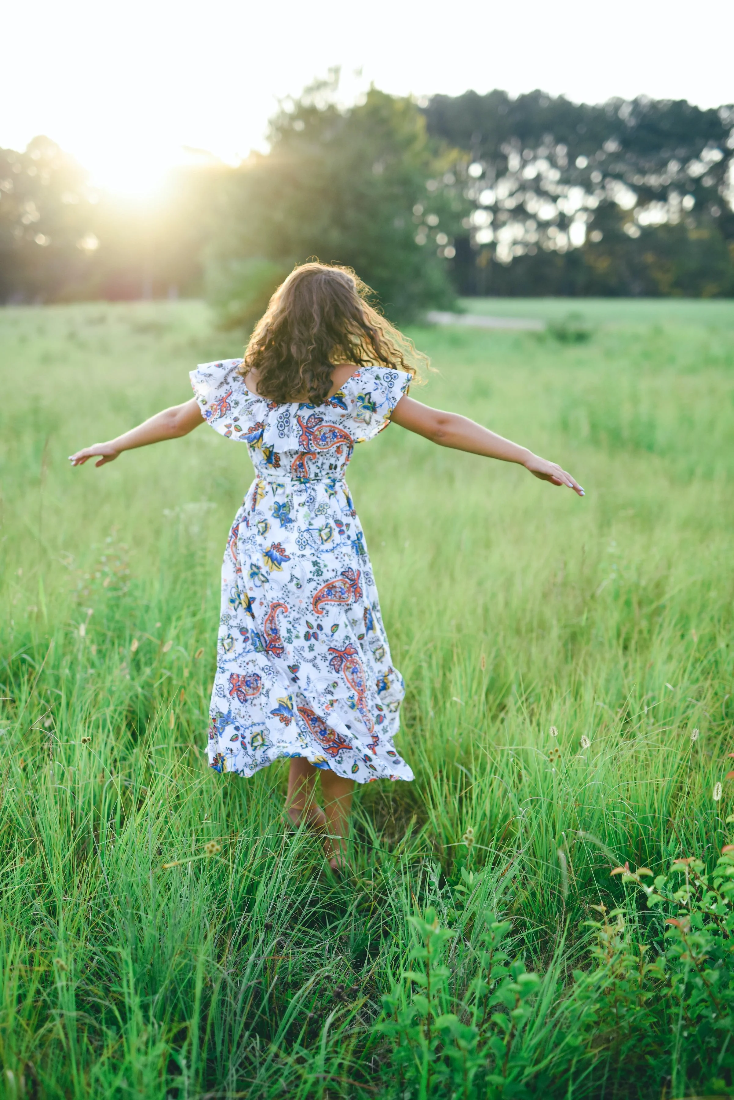 Little girl in a pretty dress running in a field