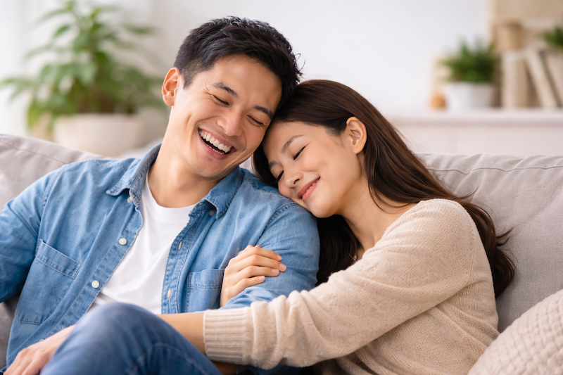 Happy Asian couple relaxing on the couch