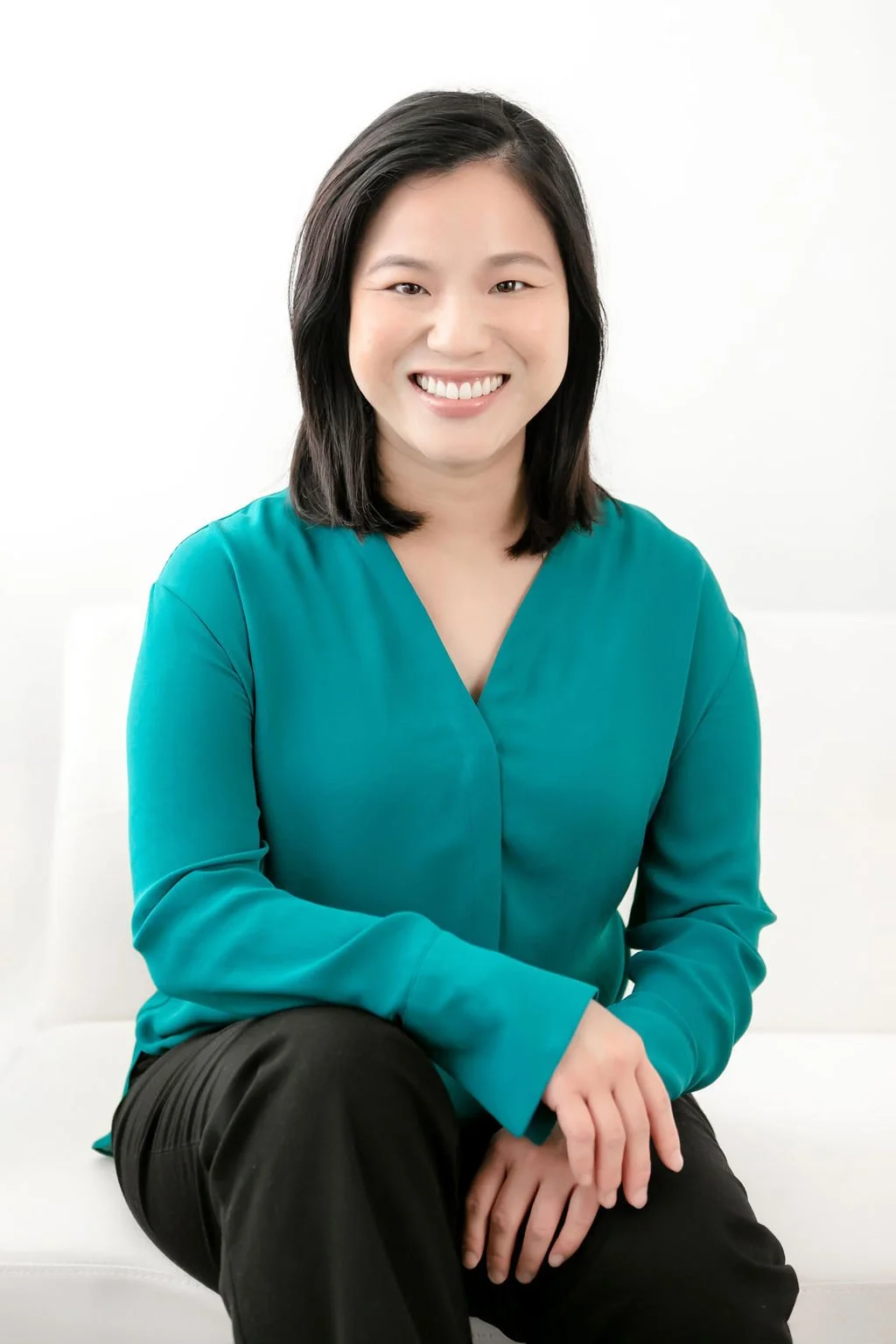 Annie Hsueh, PhD, couple therapist sitting and smiling