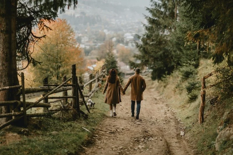 a couple holding hands and taking a walk in nature