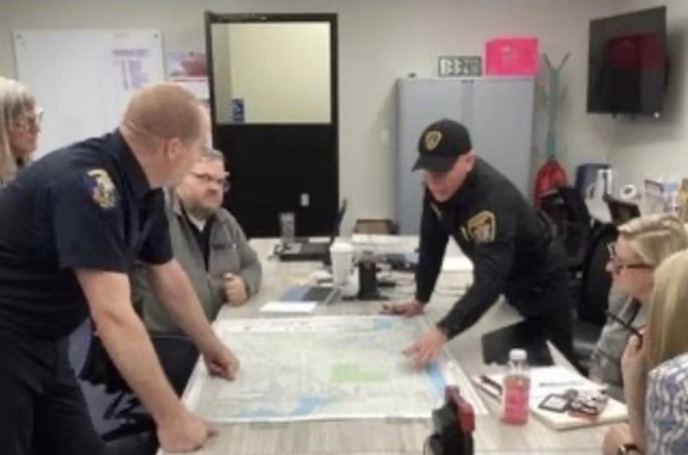 Co-lead Tami Allen, Marine Services Officer Jon Bingham, Fire DC Jeremy Mendola, COBI Emergency Manager Anne LeSage, and BP ED Dominique Cantwell, discussing evacuation routes on a fire district map.