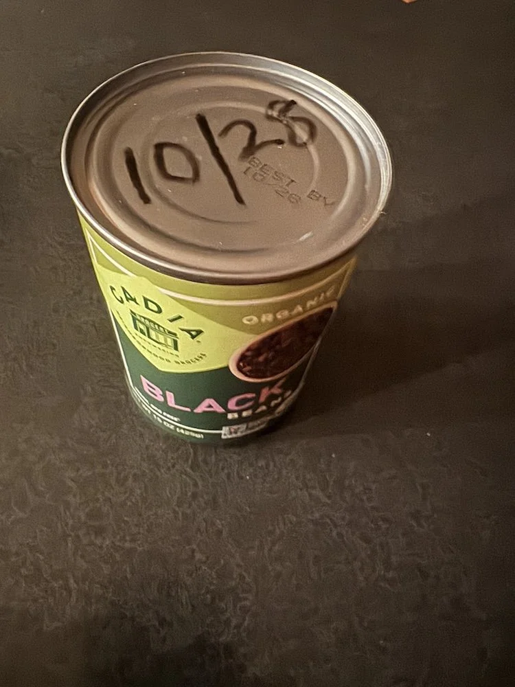 Can of beans with expiration date written on the top
