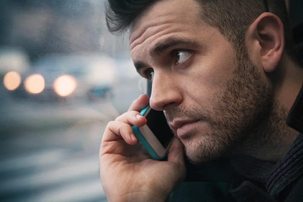 Man holding cell phone to ear and looking concerned