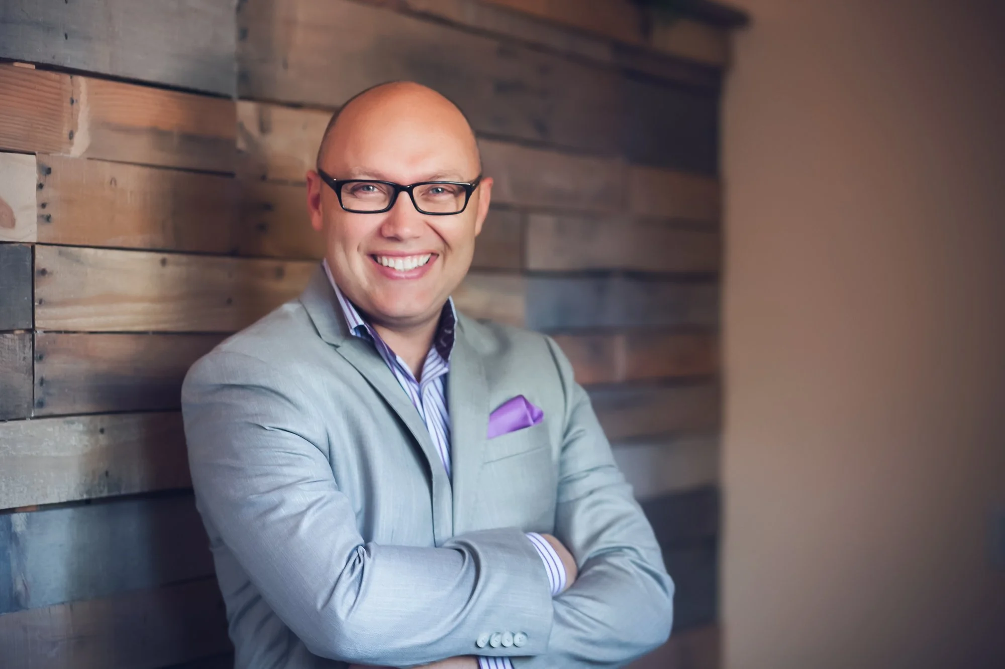 Man in grey suit smiling at the camera