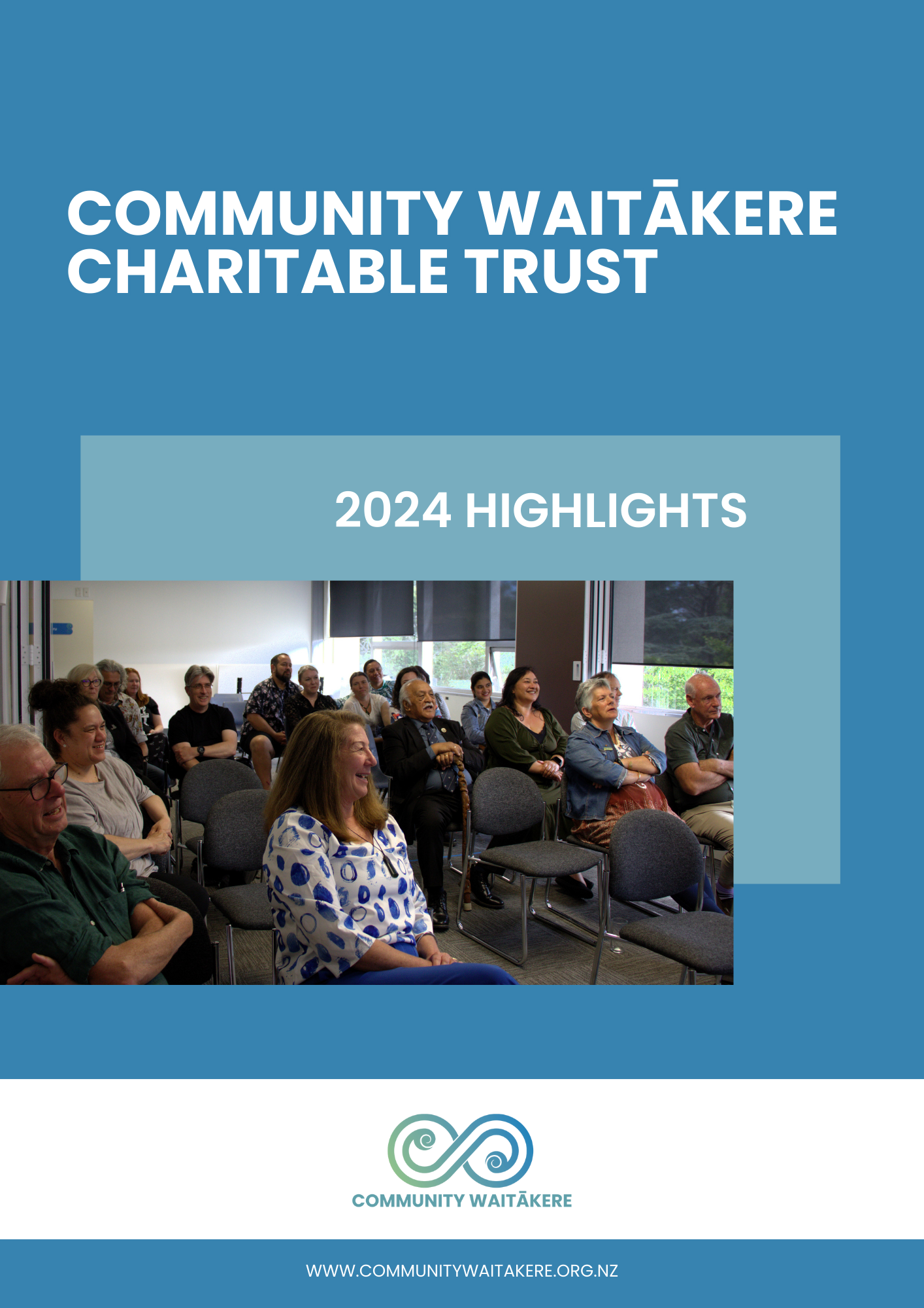 A group of diverse people sitting and listening in a meeting room with large windows, some smiling and others attentively listening. The image is part of an annual report for Community Waitākere with their logo at the bottom.