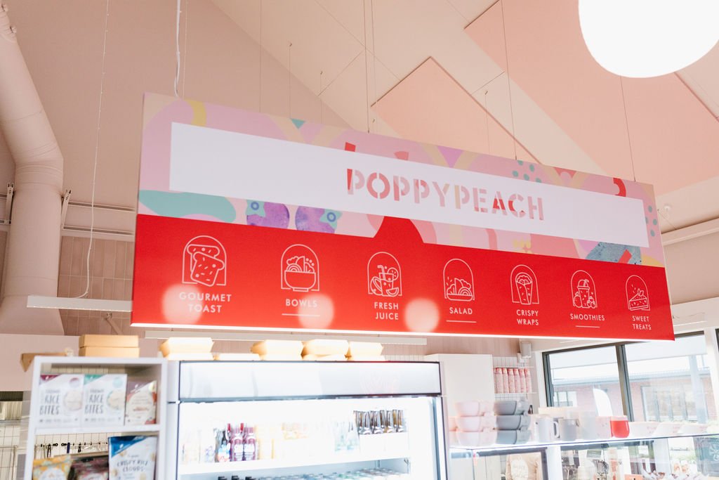 Digital menu board for Poppy Peach featuring icons and text for gourmet toast, bowls, fresh juice, salad, crispy wraps, smoothies, and sweet treats.