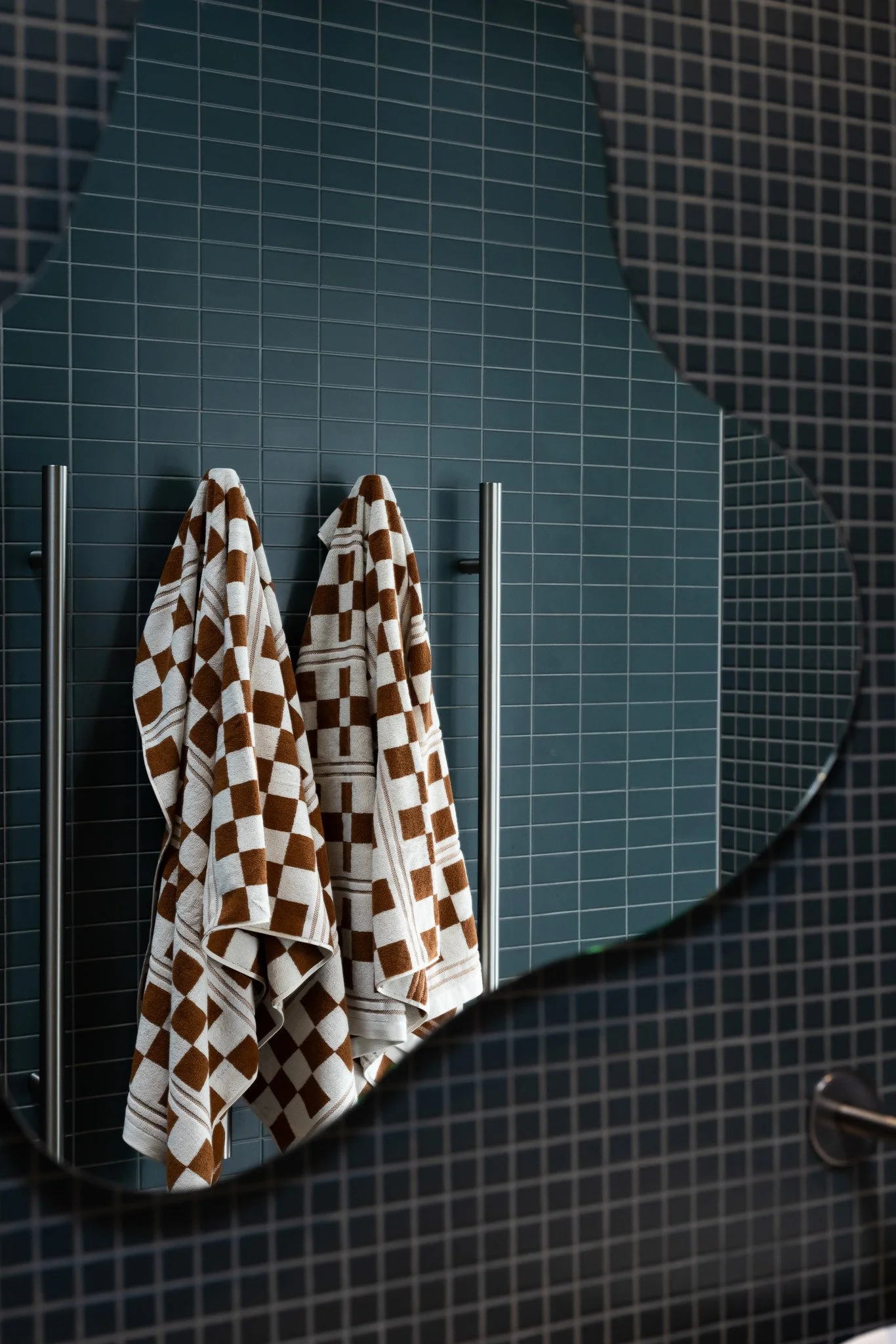 Close-up of a blue tiled cabinet in a living room with a gray sofa and blue cushions in the background.