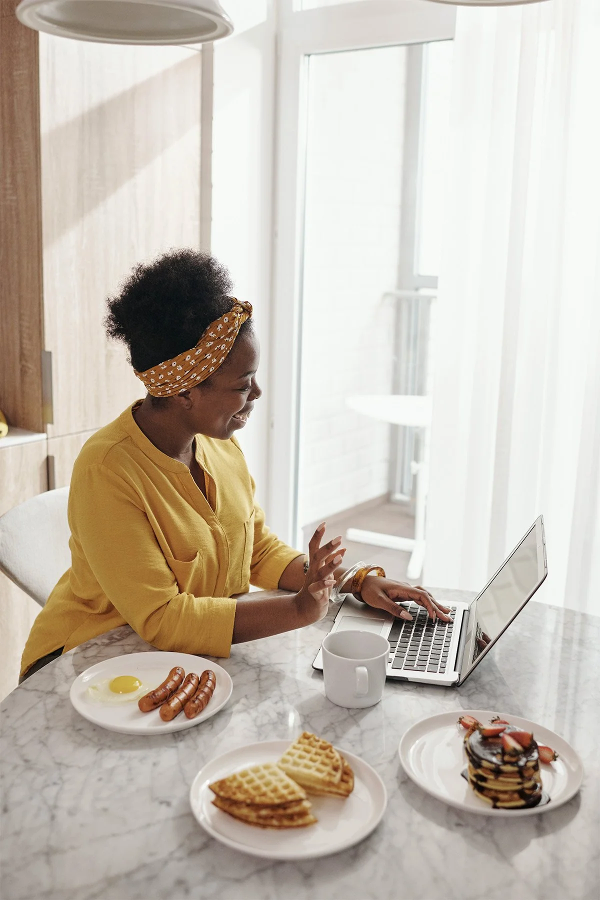 Woman eating breakfast while listening to a virtual meeting