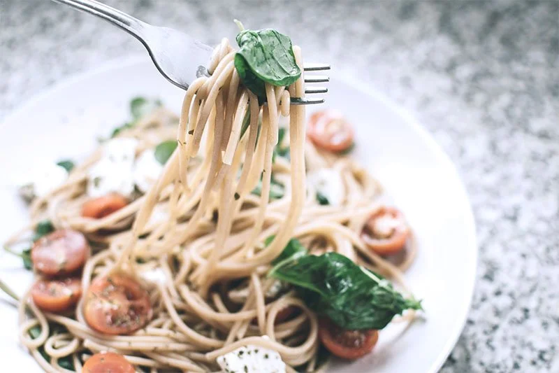 Plate of pasta with tomatoes and spinach