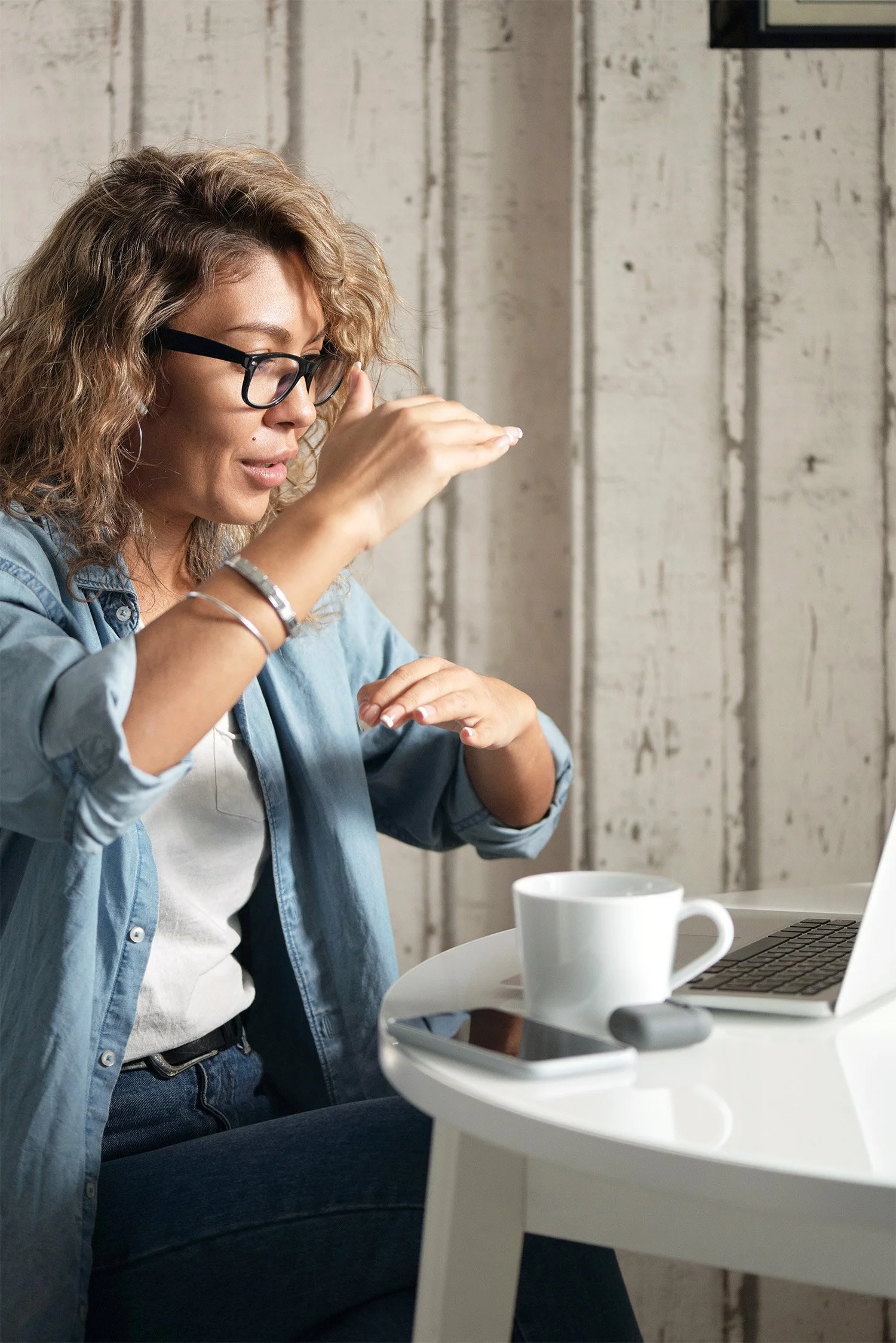 Woman gesturing and having a discussion with someone via her laptop
