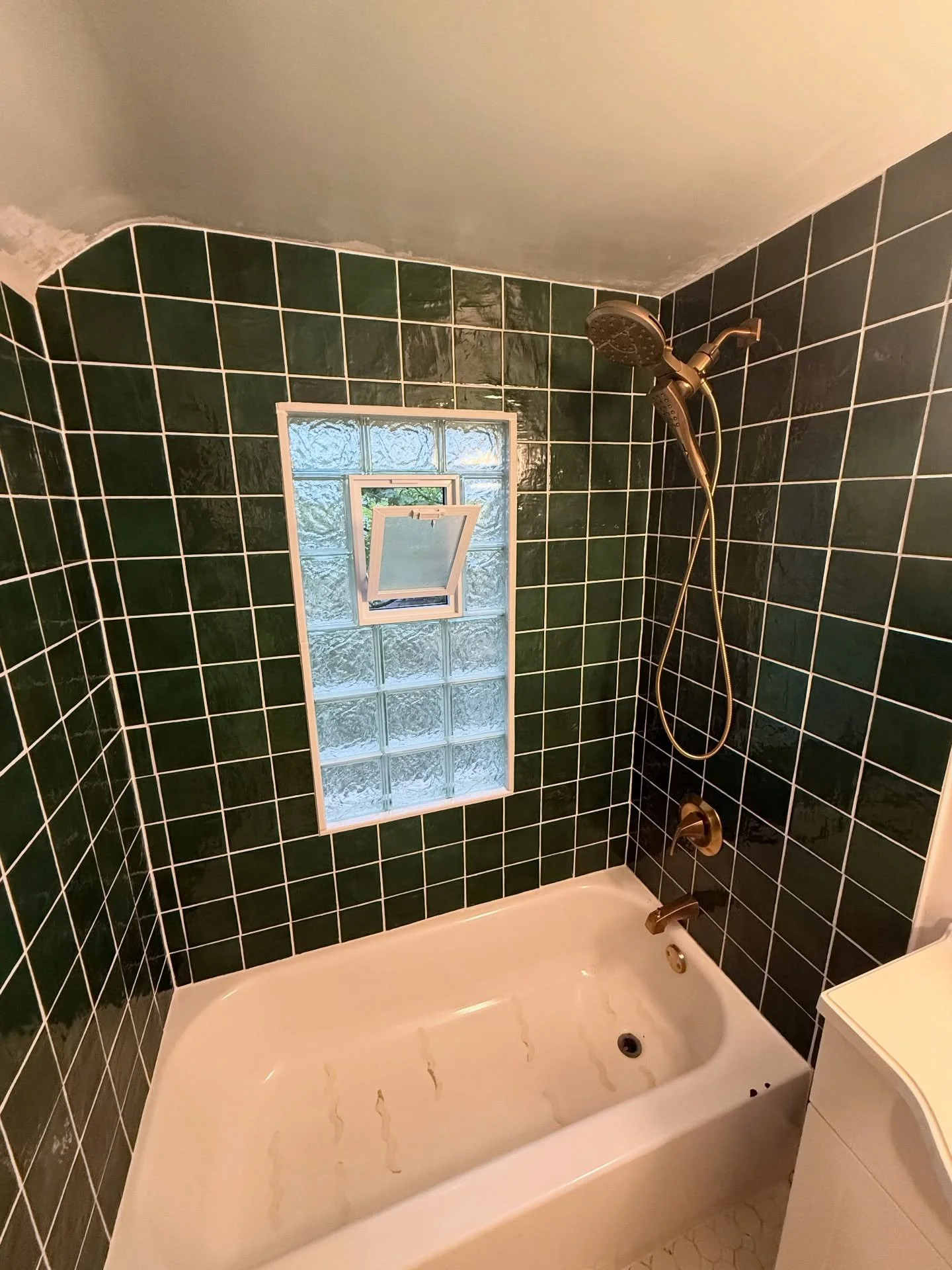Out with the old, in with the new.

After removing the original tile, we uncovered significant water damage caused by an improperly sealed glass block window. The insulation was removed, and the affected studs and window framing were repaired before 