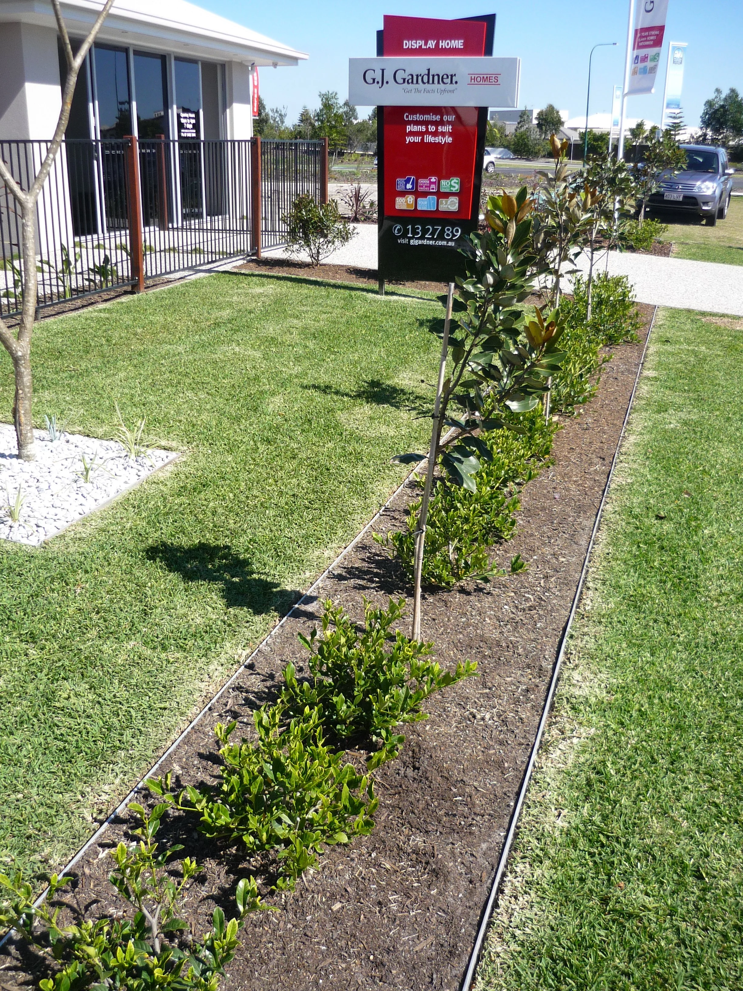 Aluminium garden edging creating a straight border between lawn and planted garden bed