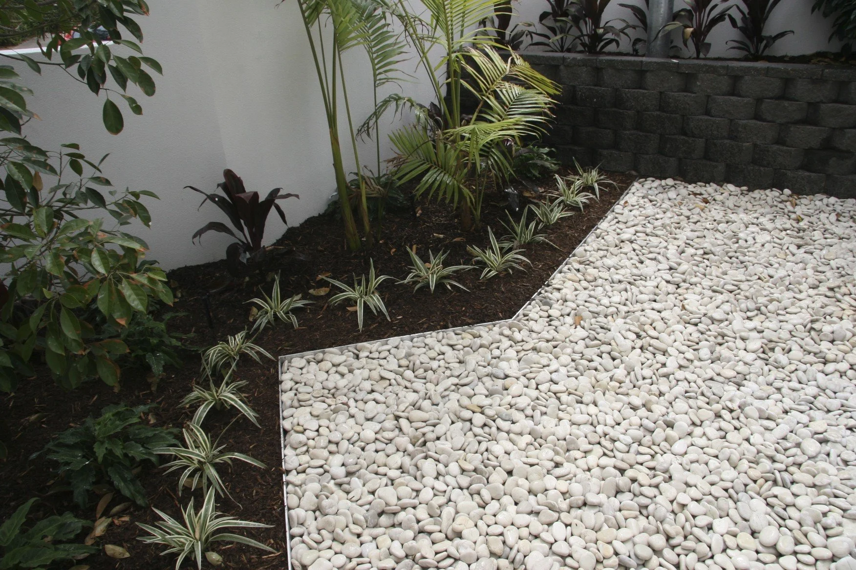 Aluminium garden edging defining a residential garden bed beside a modern home