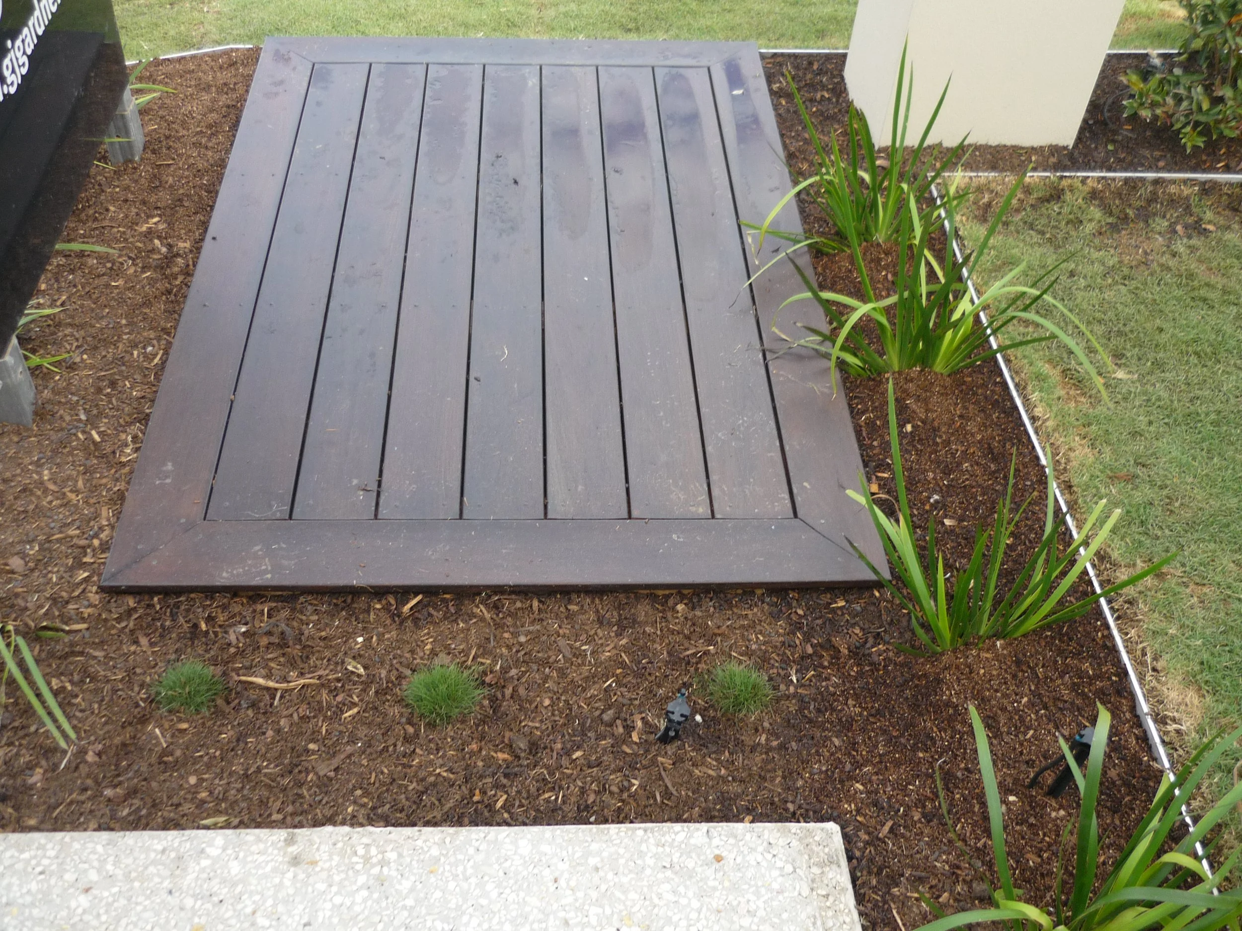 Aluminium garden edging defining planting beds around a timber garden path