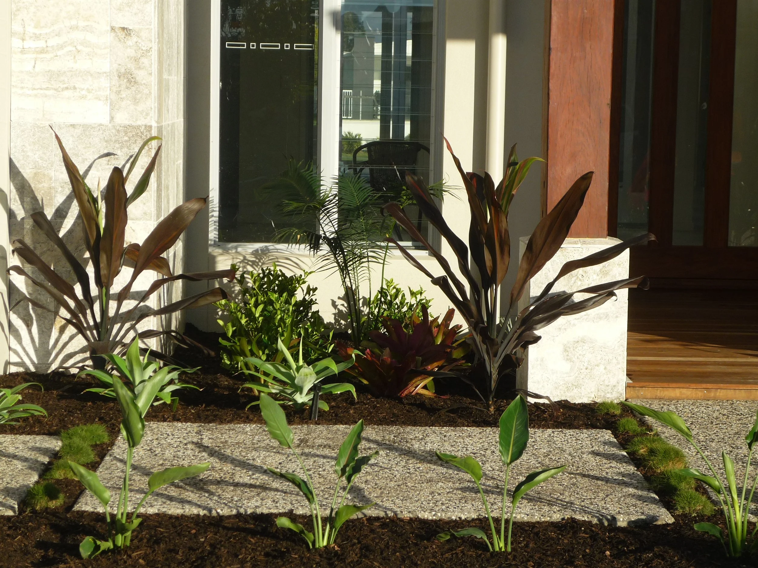 Aluminium garden edging defining a residential garden bed beside a modern home