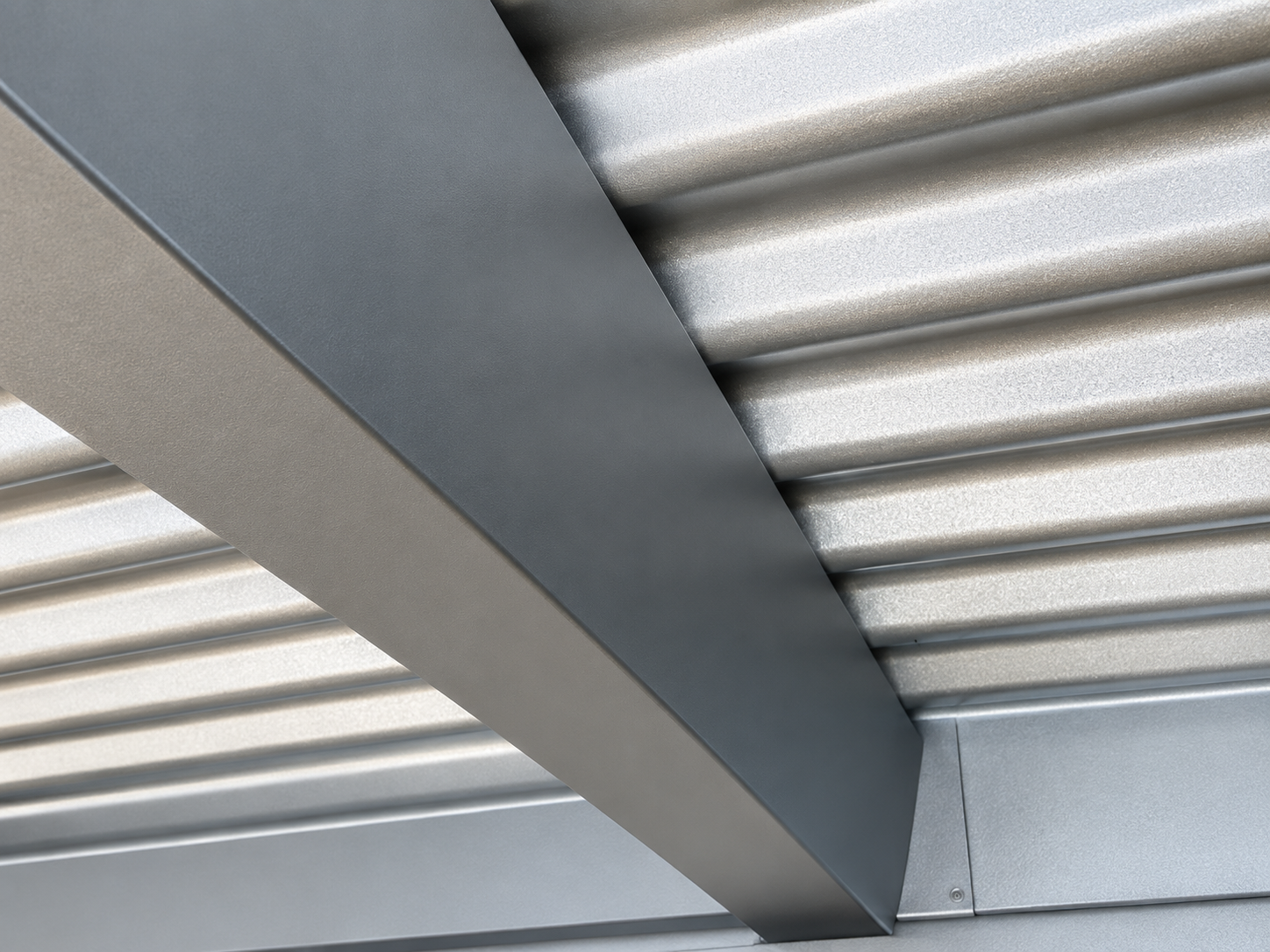 Close-up photo of a decorated metal ceiling, featuring corrugated silver panels and a dark gray beam running diagonally.