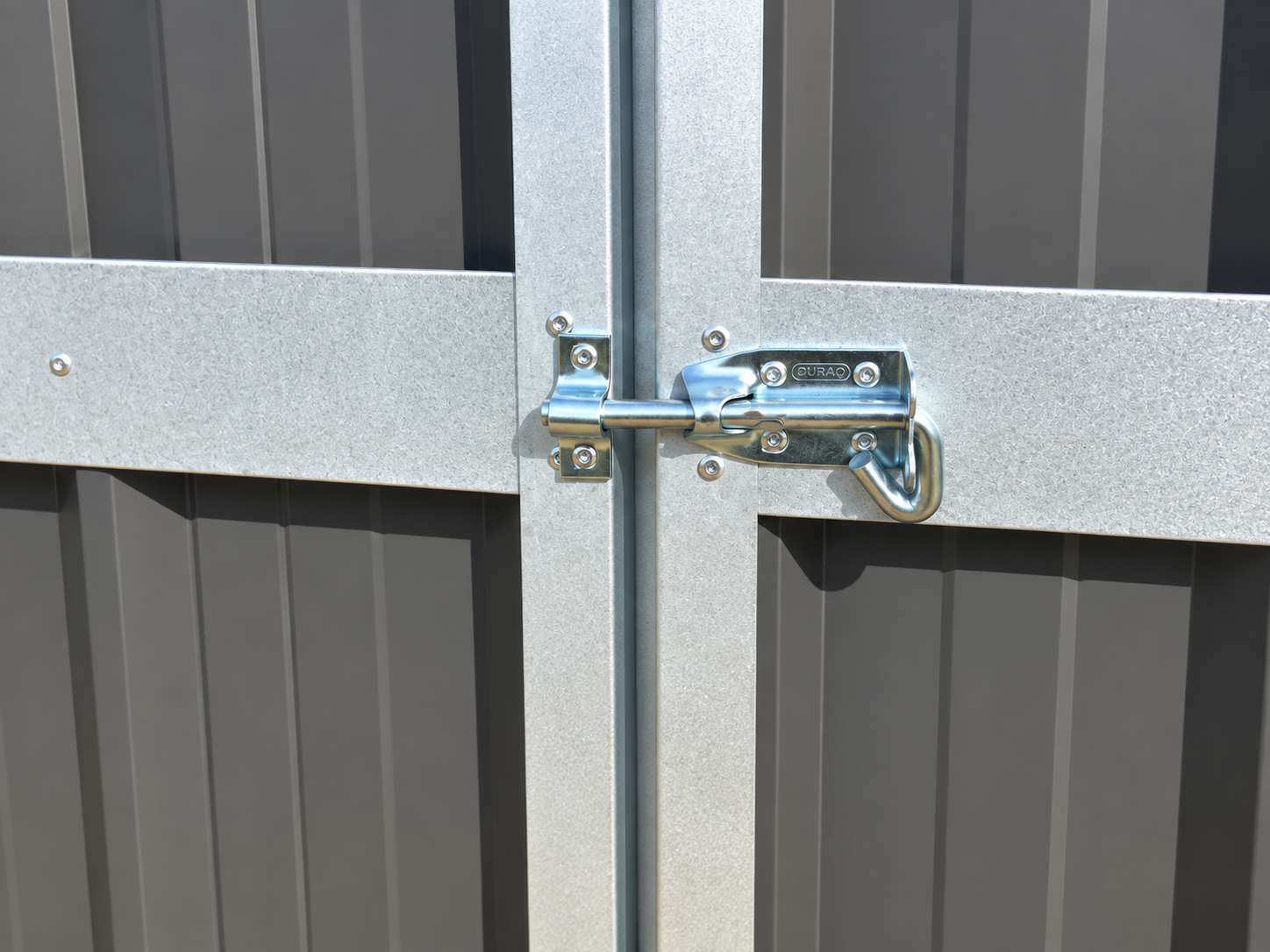A close-up of a metal latch securing two gray metal panels together.