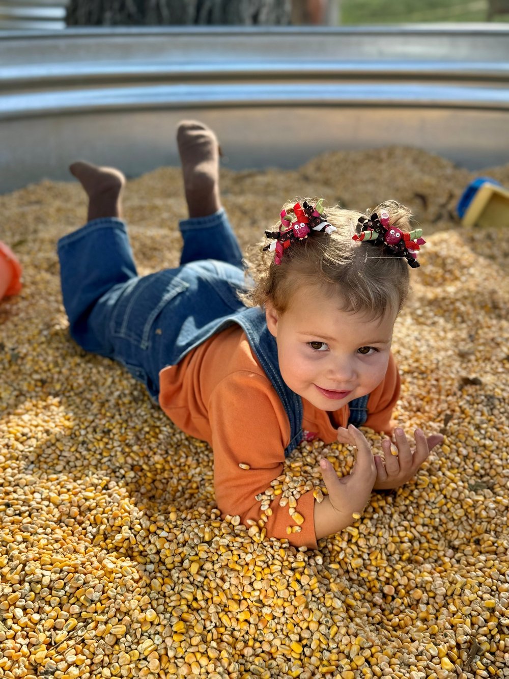 A toddler playing in the corn pit on a quiet Friday morning at Ruby Creek