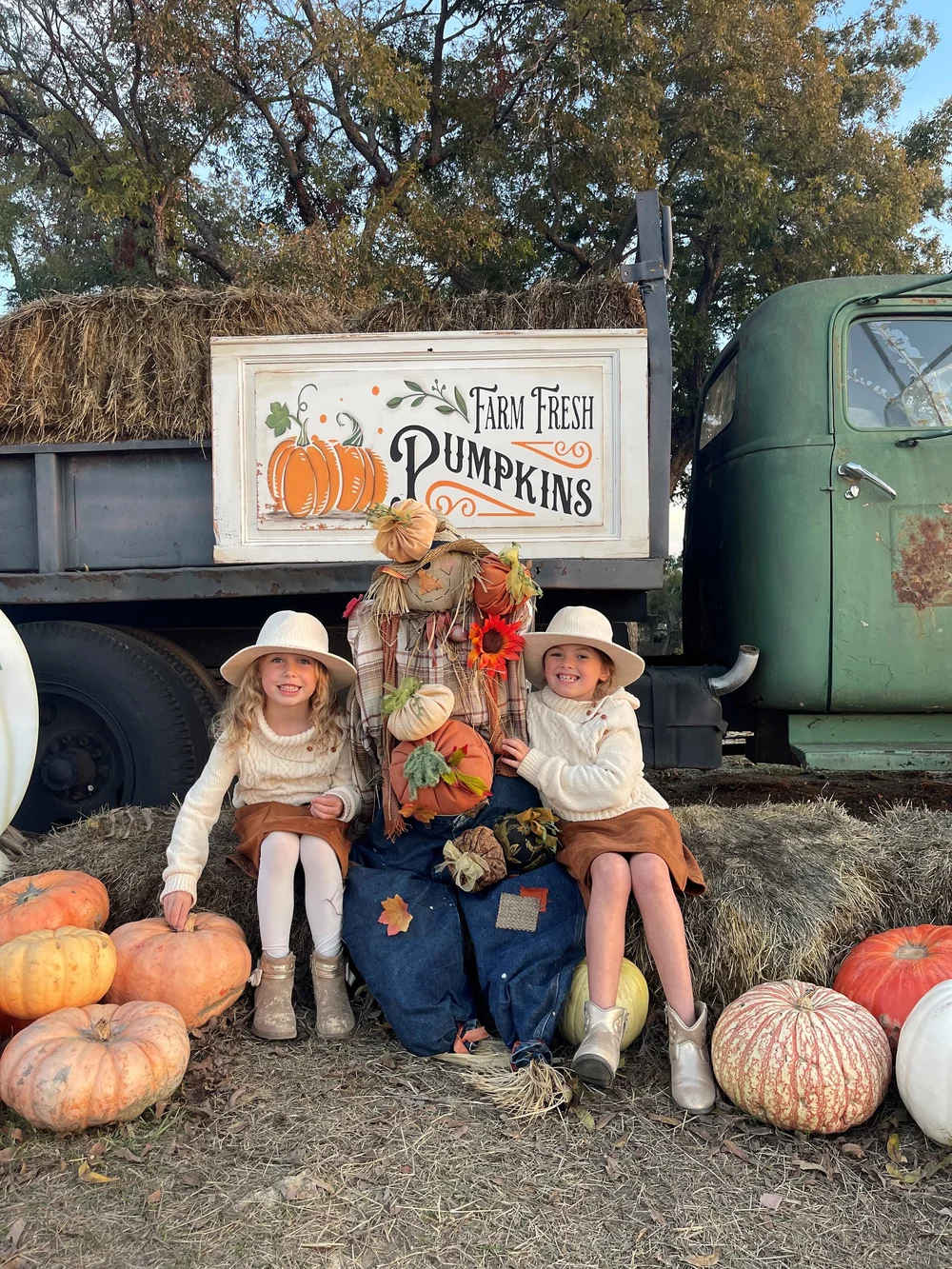 Kids posing in the vintage farm truck filled with pumpkins
