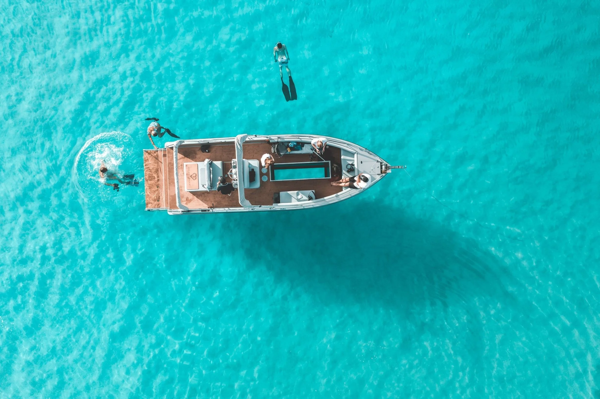 A family snorkeling together in the clear turquoise waters of the Great Barrier Reef, Australia, exploring on a private tour.