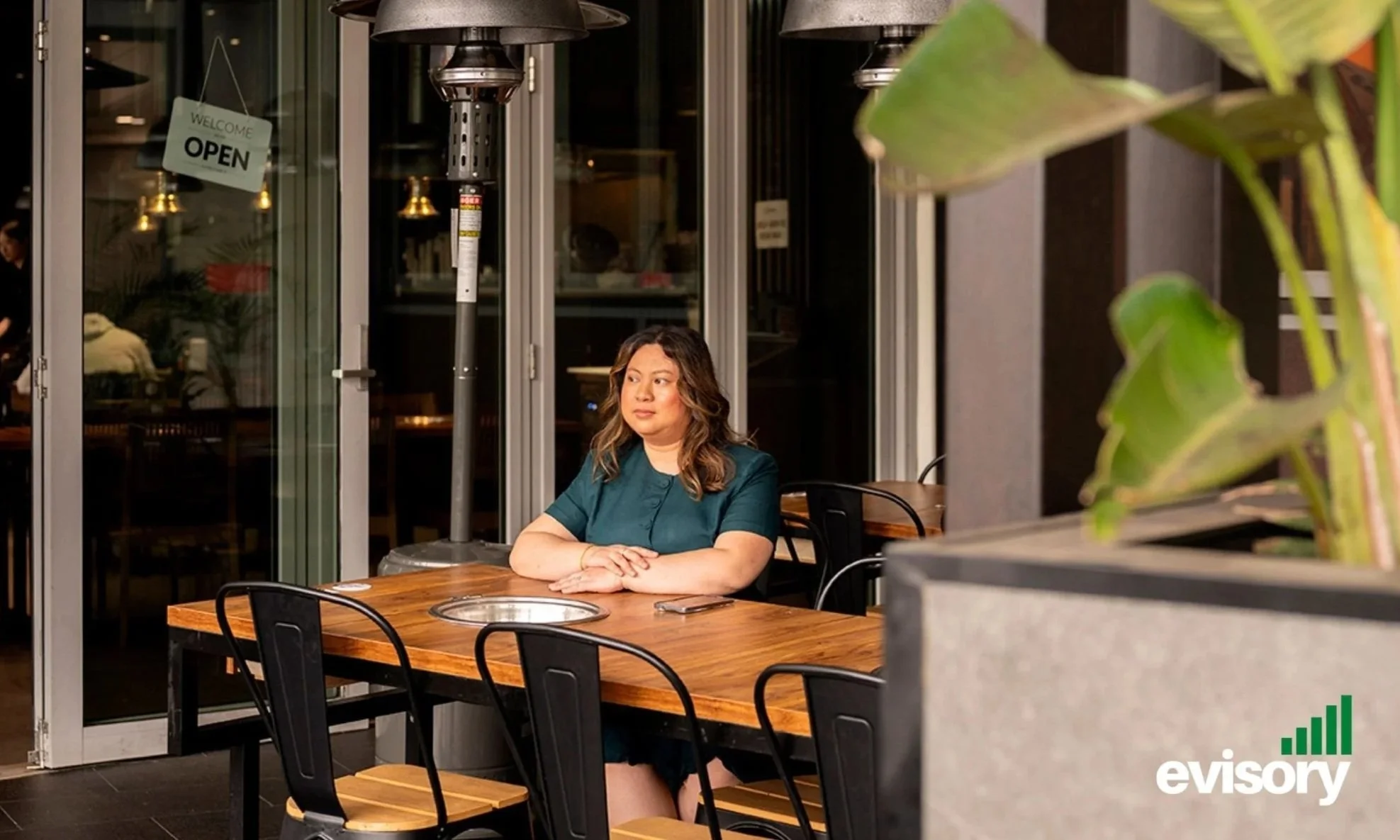 Evisory CEO Linda Dang at a restaurant table conducting an end-of-year financial strategy meeting.