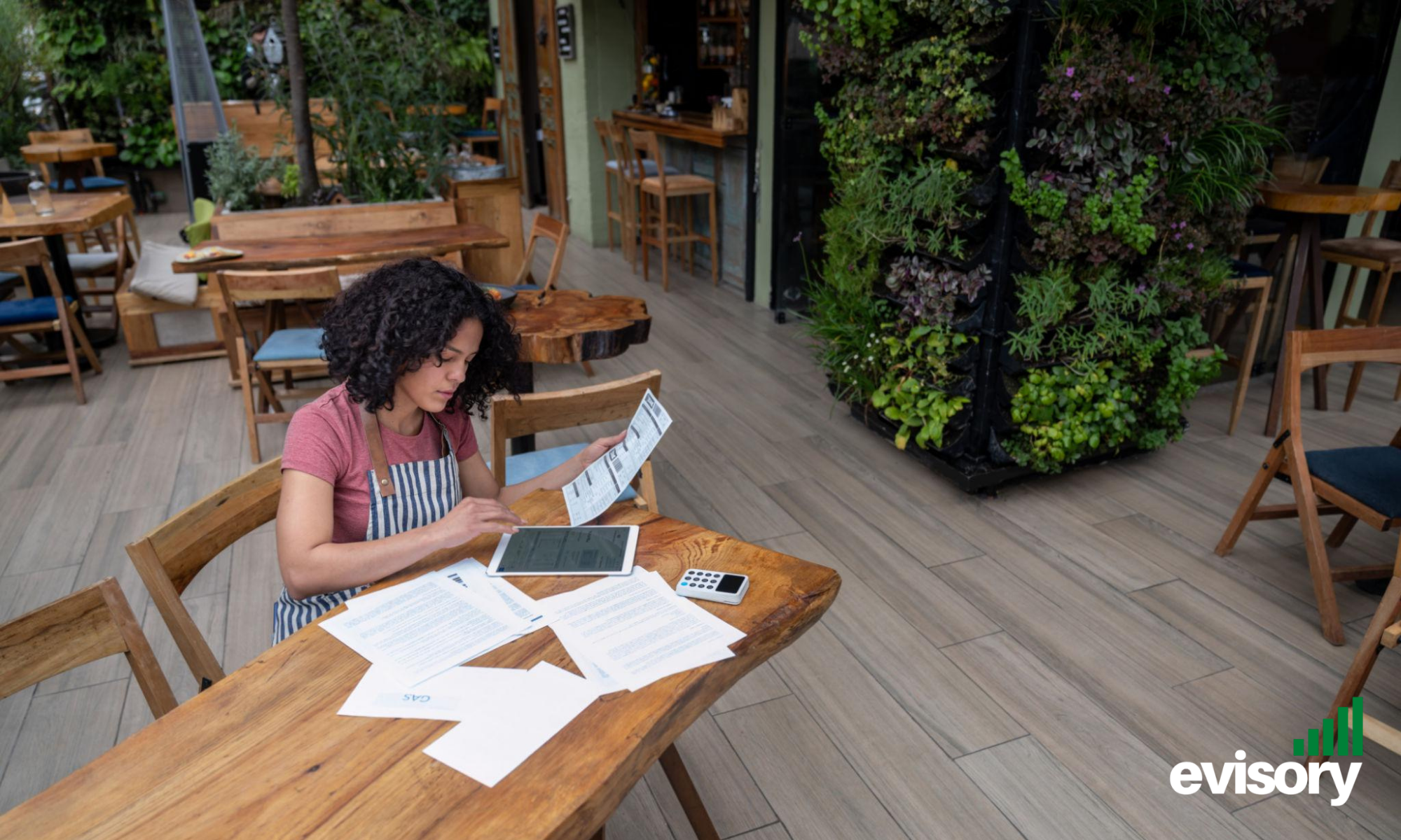 Café manager reviewing hospitality payroll and labour cost reports