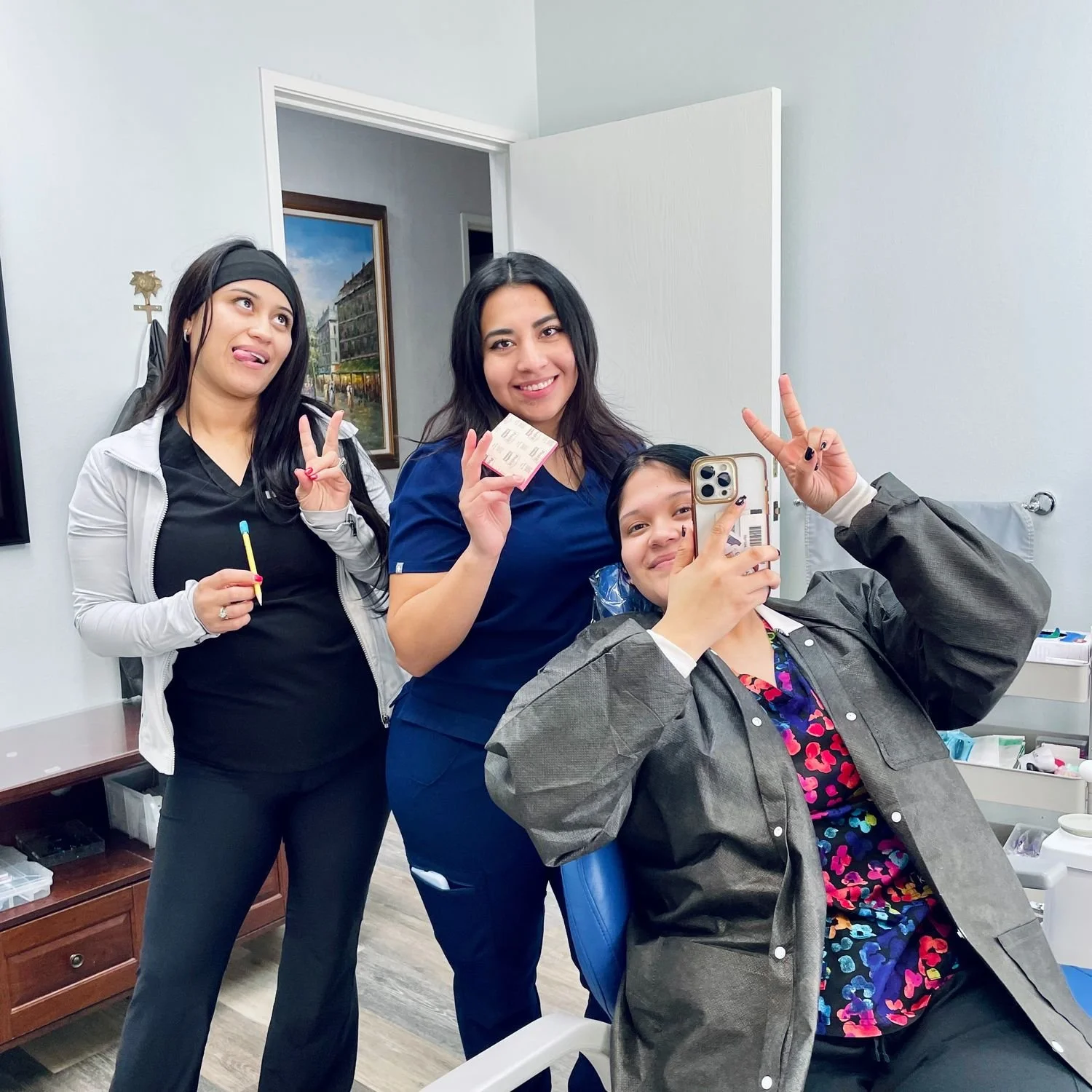 Dental assistants at Orange Villa Smiles posing together in an operatory, smiling and celebrating during a patient visit