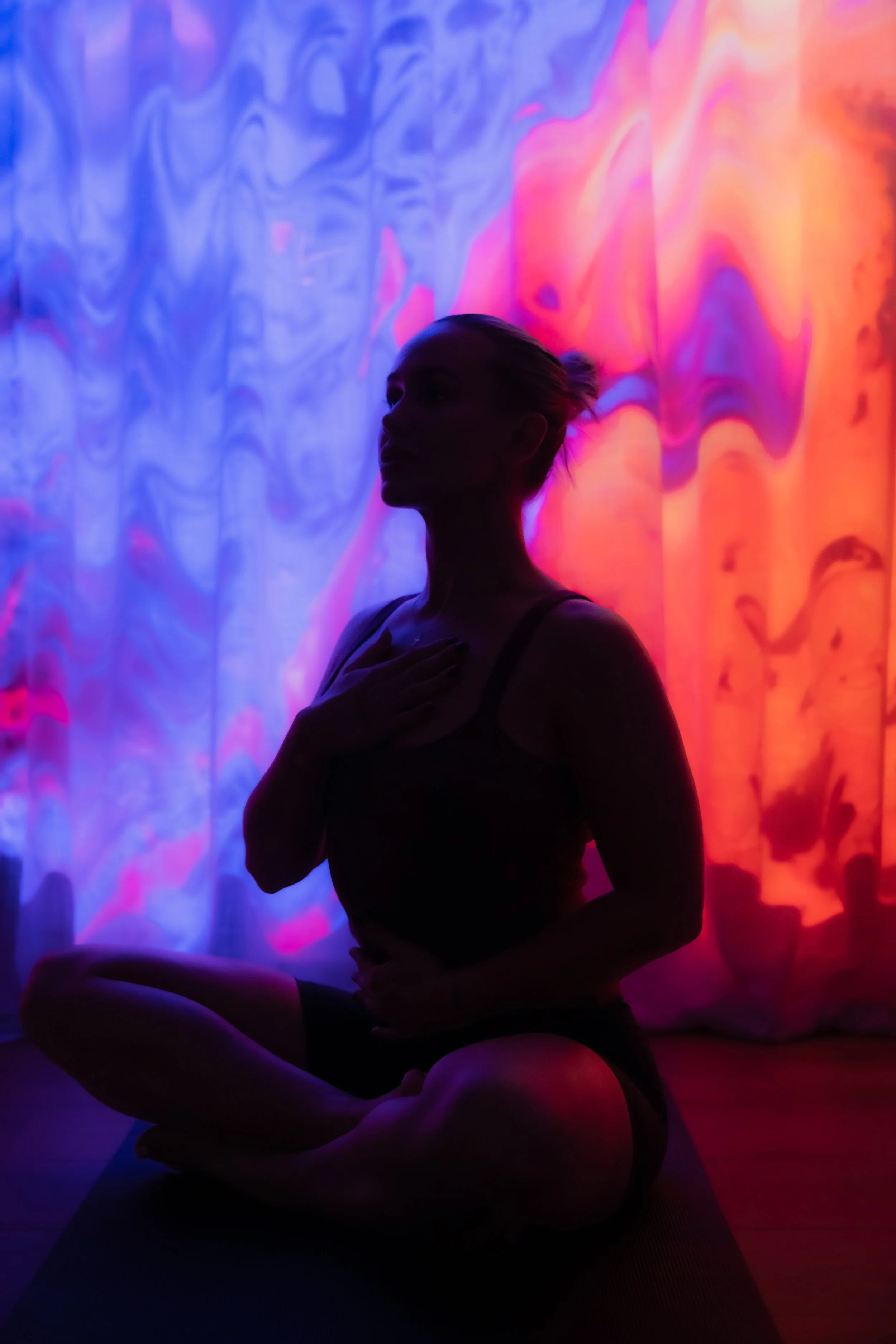 Breathwork surrounded by vivid pink and purple light at The Breath Haus