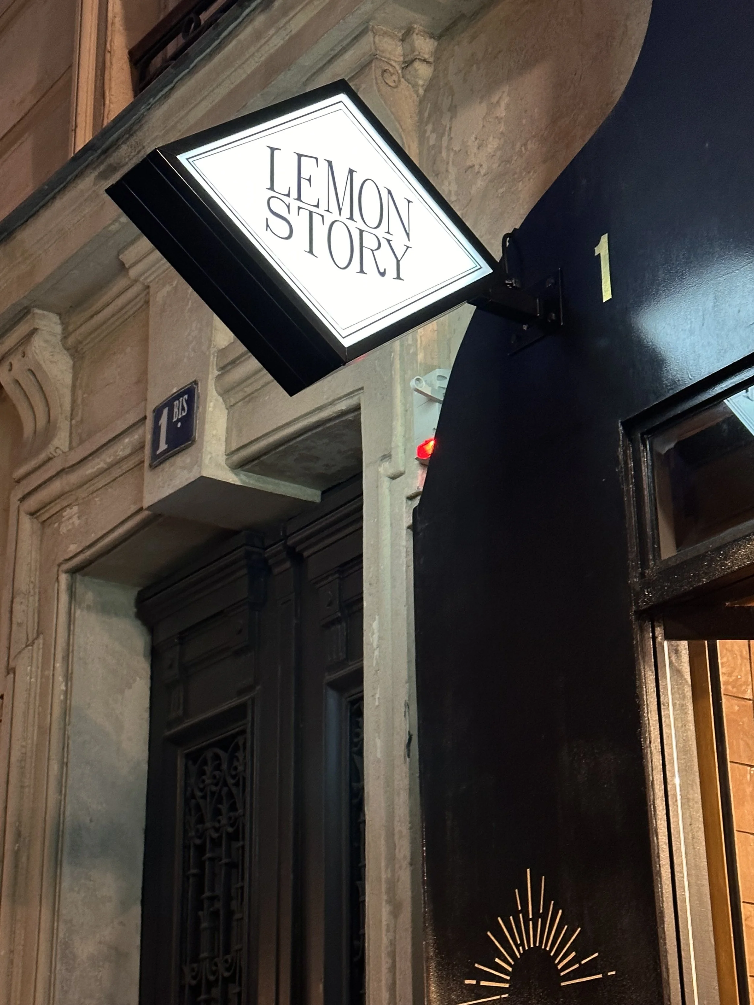 Enseigne lumineuse Lemon Story, sur la façade de la boutique, dans la rue, la nuit.