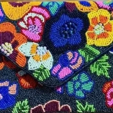 Close-up of colorful floral embroidery with various flowers and green leaves.