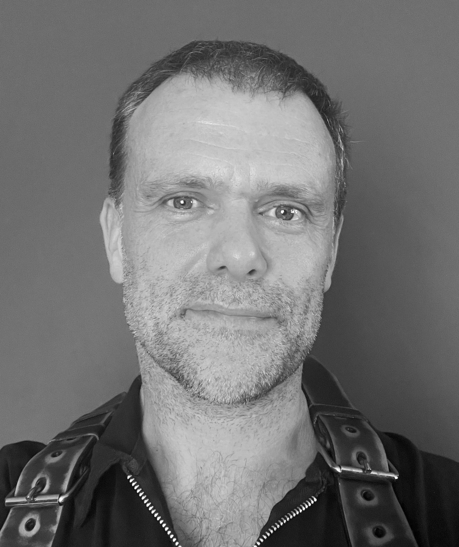 Close-up black-and-white photo of a middle-aged man who is the wedding photographer promoting himself on this website